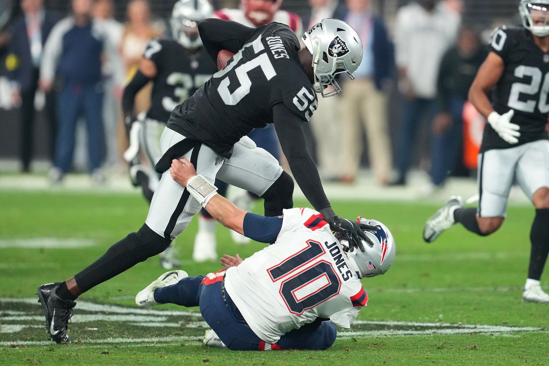 Las Vegas Raiders defensive end Chandler Jones (55) stiff-arms New England Patriots quarterback Mac Jones (10) on the way to scoring a touchdown at the end of the second half at Allegiant Stadium in Paradise, Nevada on Dec. 18, 2022.