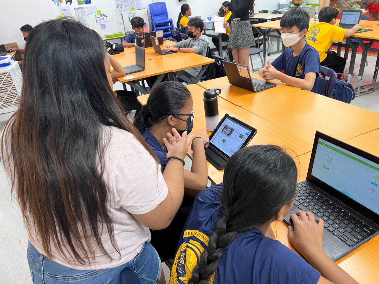 Tutor Frankye Fracesca Ada, left, back facing camera, guides her Hopwood Middle School students.