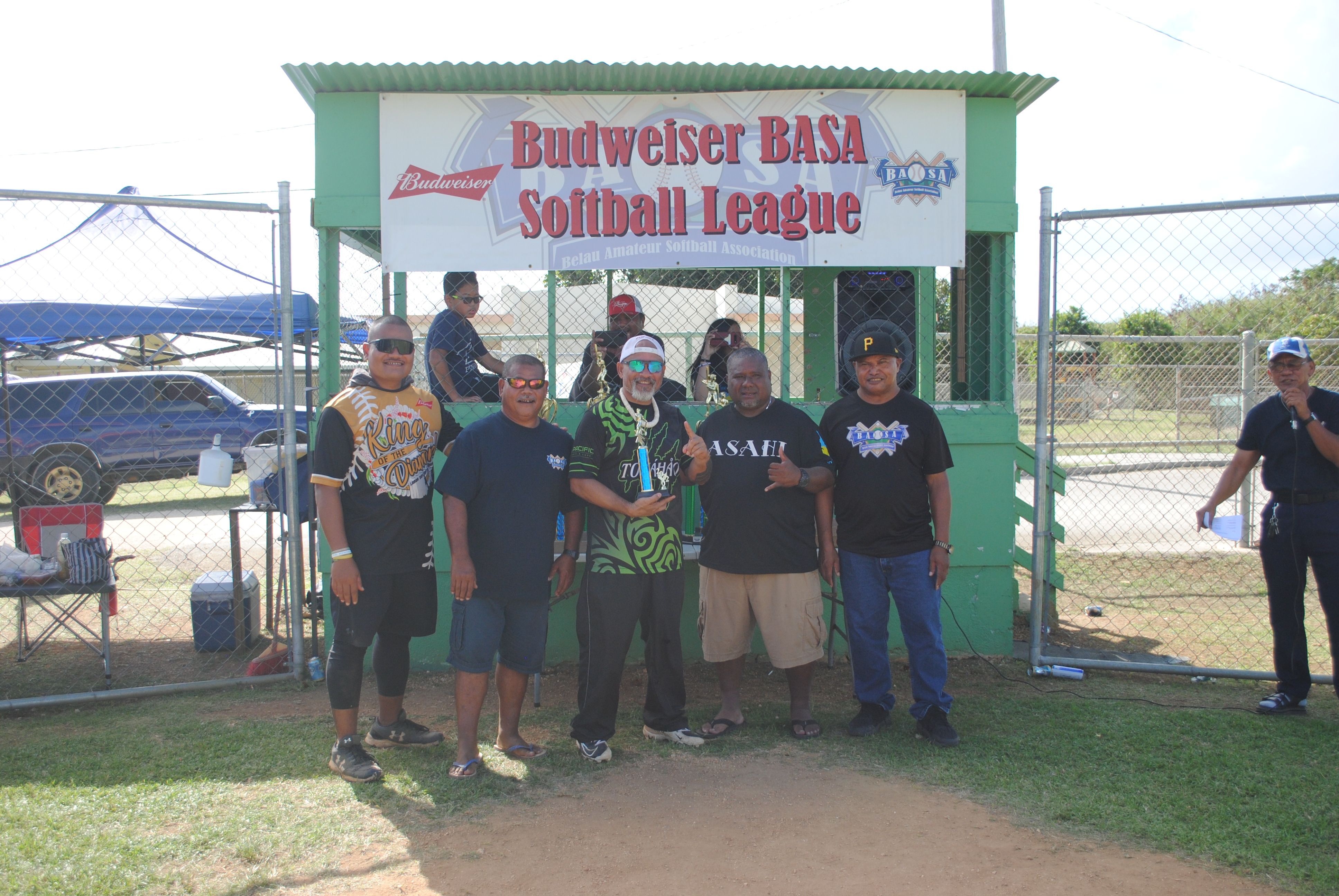 George David, the men’s division championship MVP, poses for a photo with Belau Amateur Softball Association officials at the Dandan baseball field on Sunday.