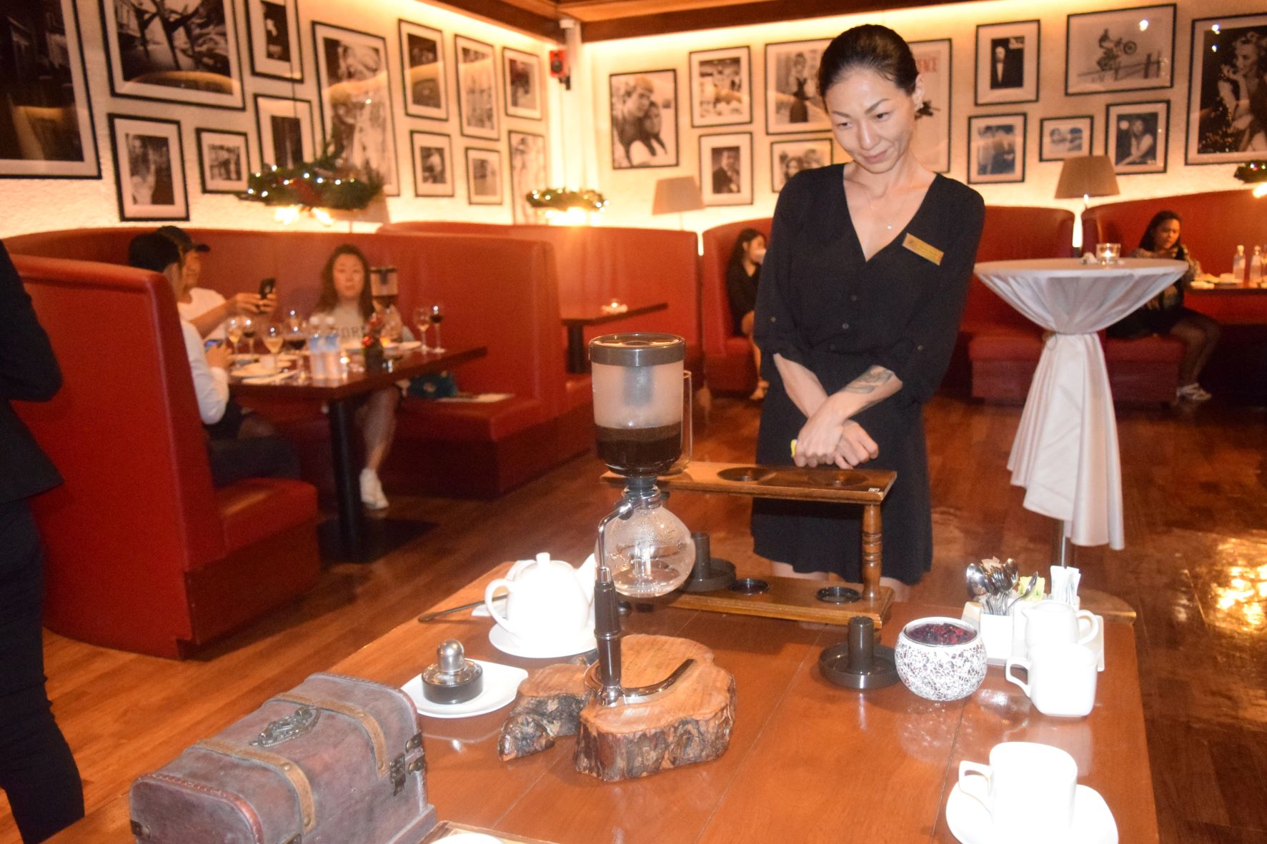 Aqua Resort Club Marketing & Public Relations Assistant Victoria Barnes looks admiringly at a classic coffee maker that was showcased during the reopening of Kevin's Prime Rib & Seafood at Aqua Resort Club on Dec. 1, 2022.