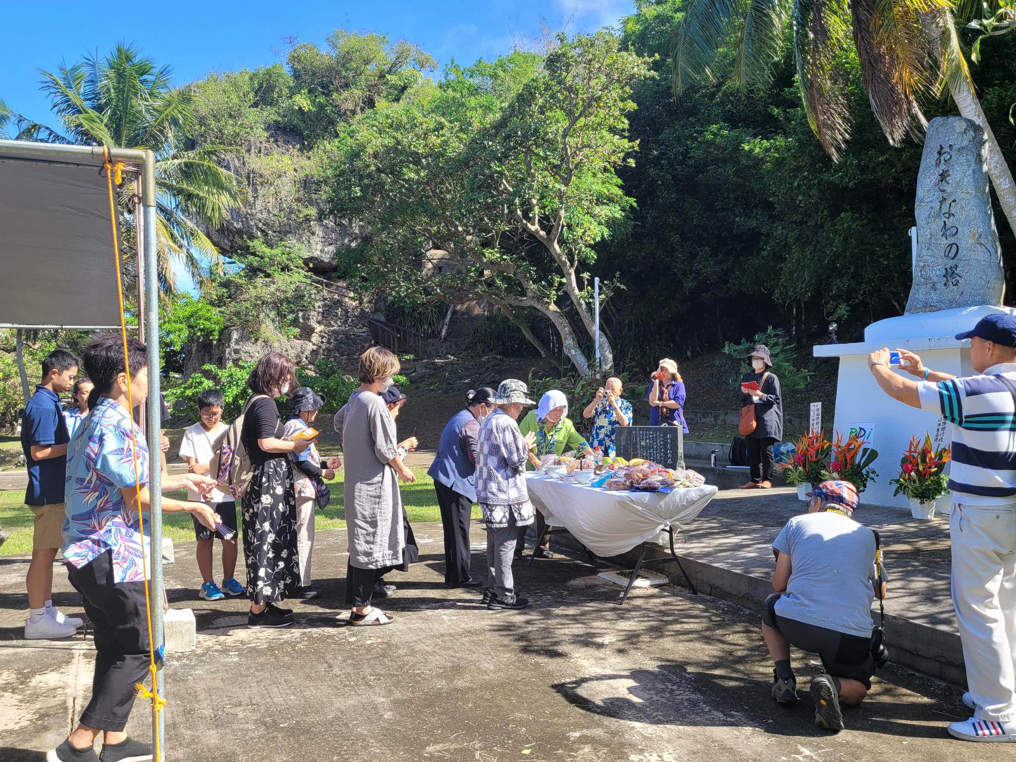 A visiting Okinawan group holds memorial services at the Okinawa Peace Memorial in Marpi  on Dec. 4, 2022. Also in photo are some local residents who joined the Okinawans in offering prayers for peace.