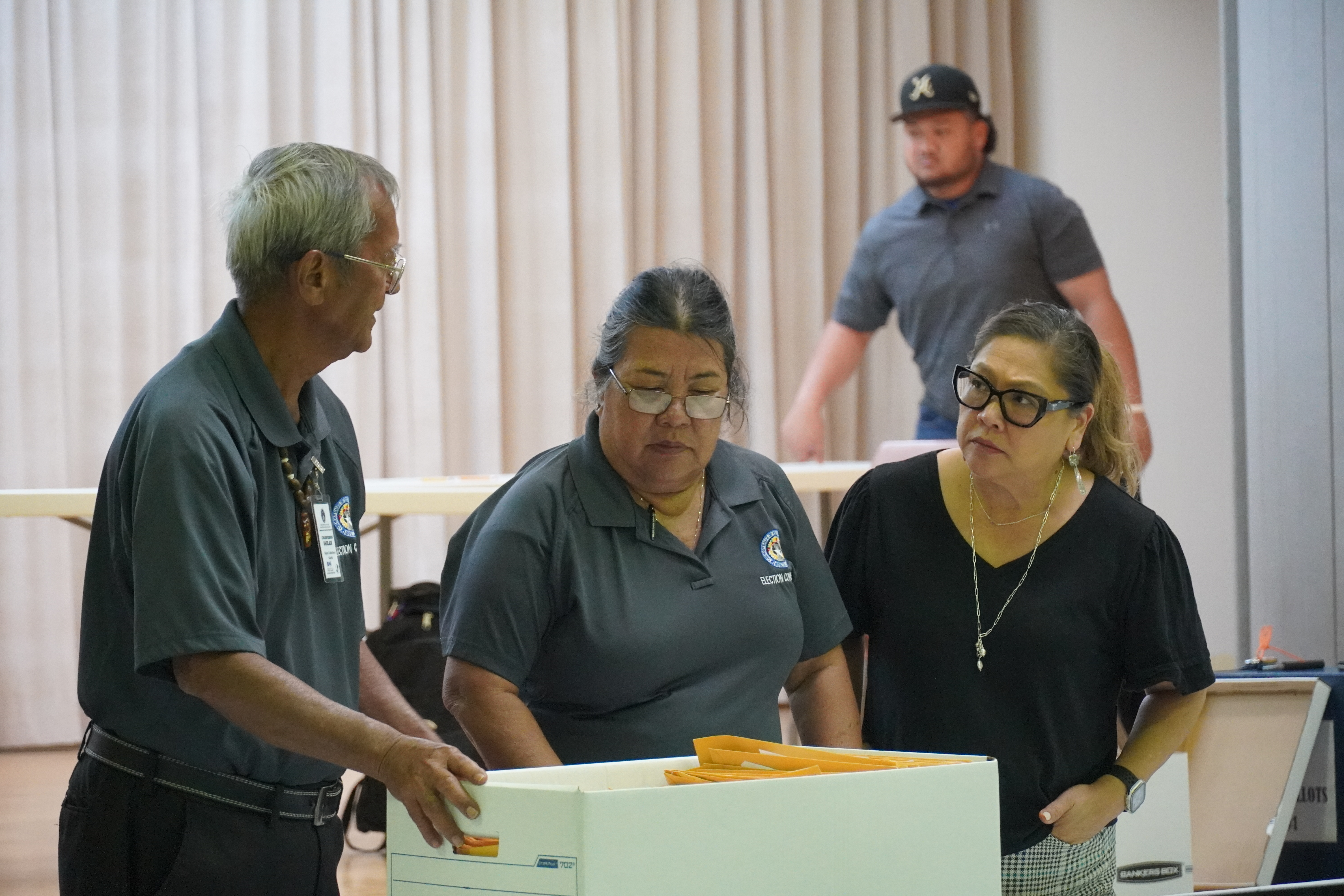 Election board chair Jesus I. Sablan speaks to vice chair Esther Yatar, center, and election commissioner Dorisann Aldan-Atalig, right.