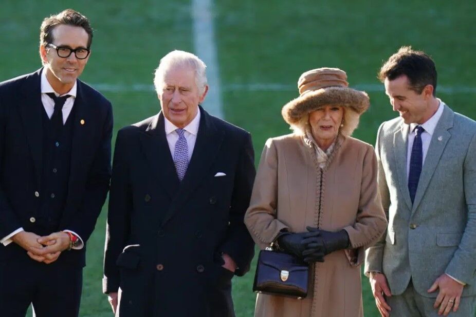 Britain's King Charles III and Camilla, the Queen Consort speak to Wrexham Soccer team co-owners, U.S. actors Ryan Reynolds, left and Rob McElhenney during their visit to Wrexham Association Football Club's Racecourse Ground, in Wrexham, England, Friday, Dec. 9, 2022.