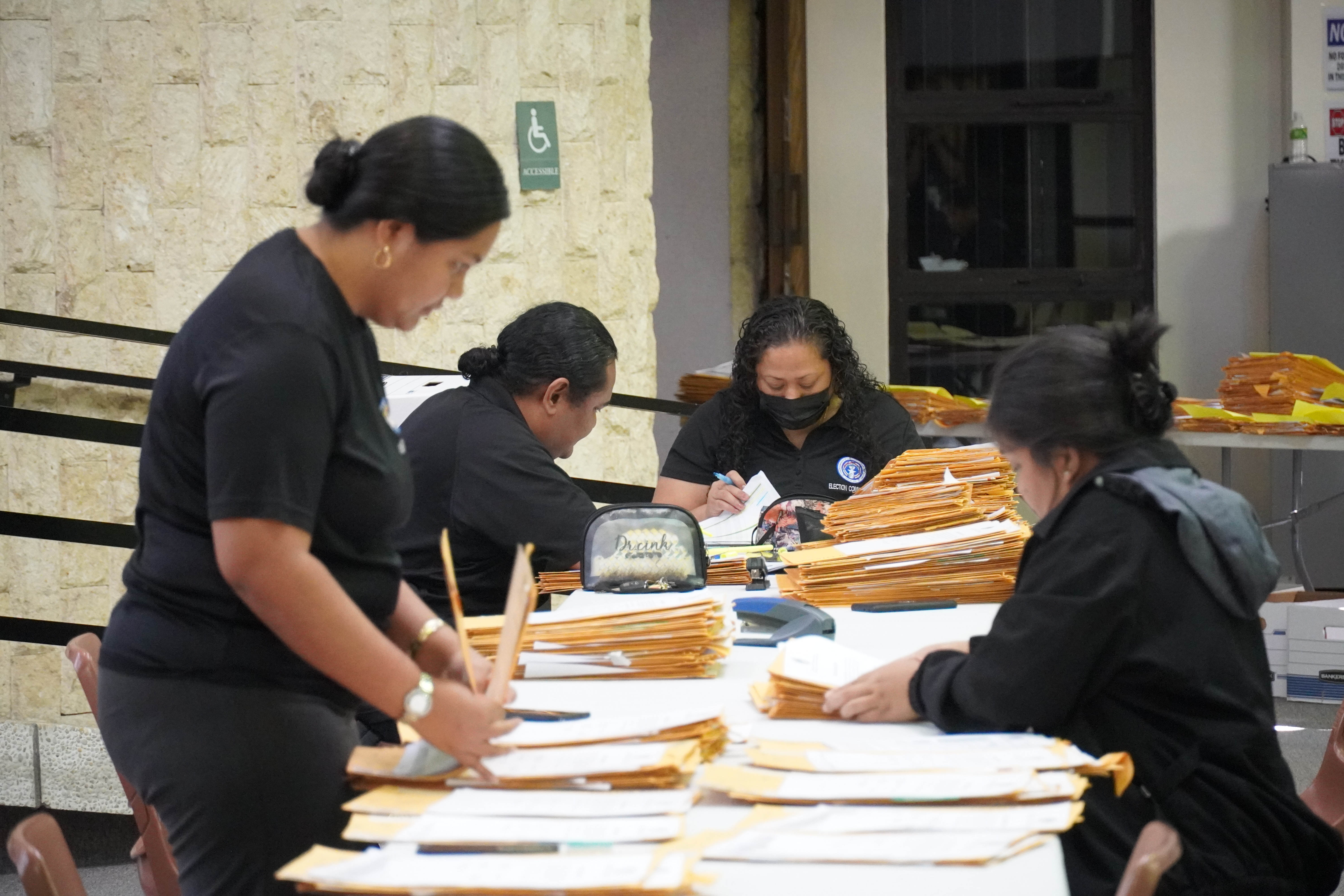 Commonwealth Election Commission Executive Director Kayla S. Igitol, center, and staff members sort through the last batch of absentee ballots late Friday afternoon at the Gov. Pedro P. Tenorio Multi-Purpose Center.