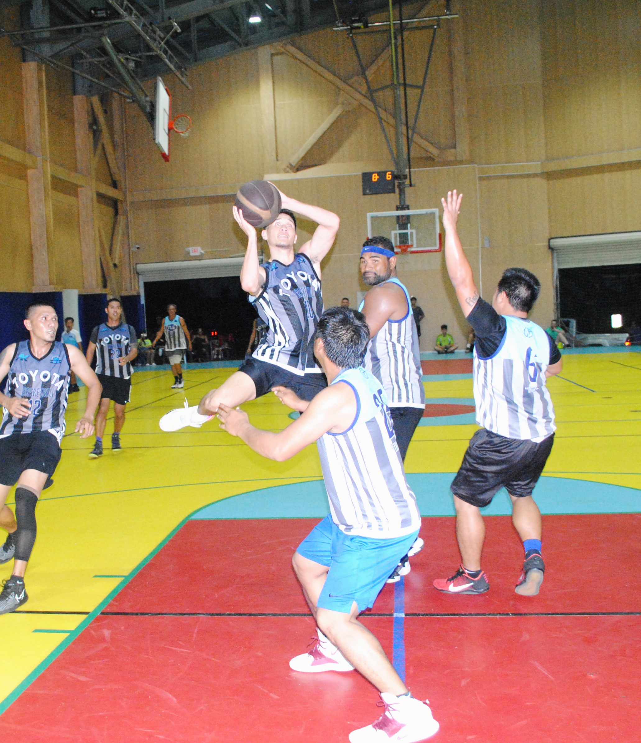 AK Toyota's Shane Deleon Guerrero takes the off-balanced shot against three IT&E defenders during the championship game of the inaugural Marianas International Basketball League Fantasy Draft Tournament on Friday at the Agape Christian School gym.