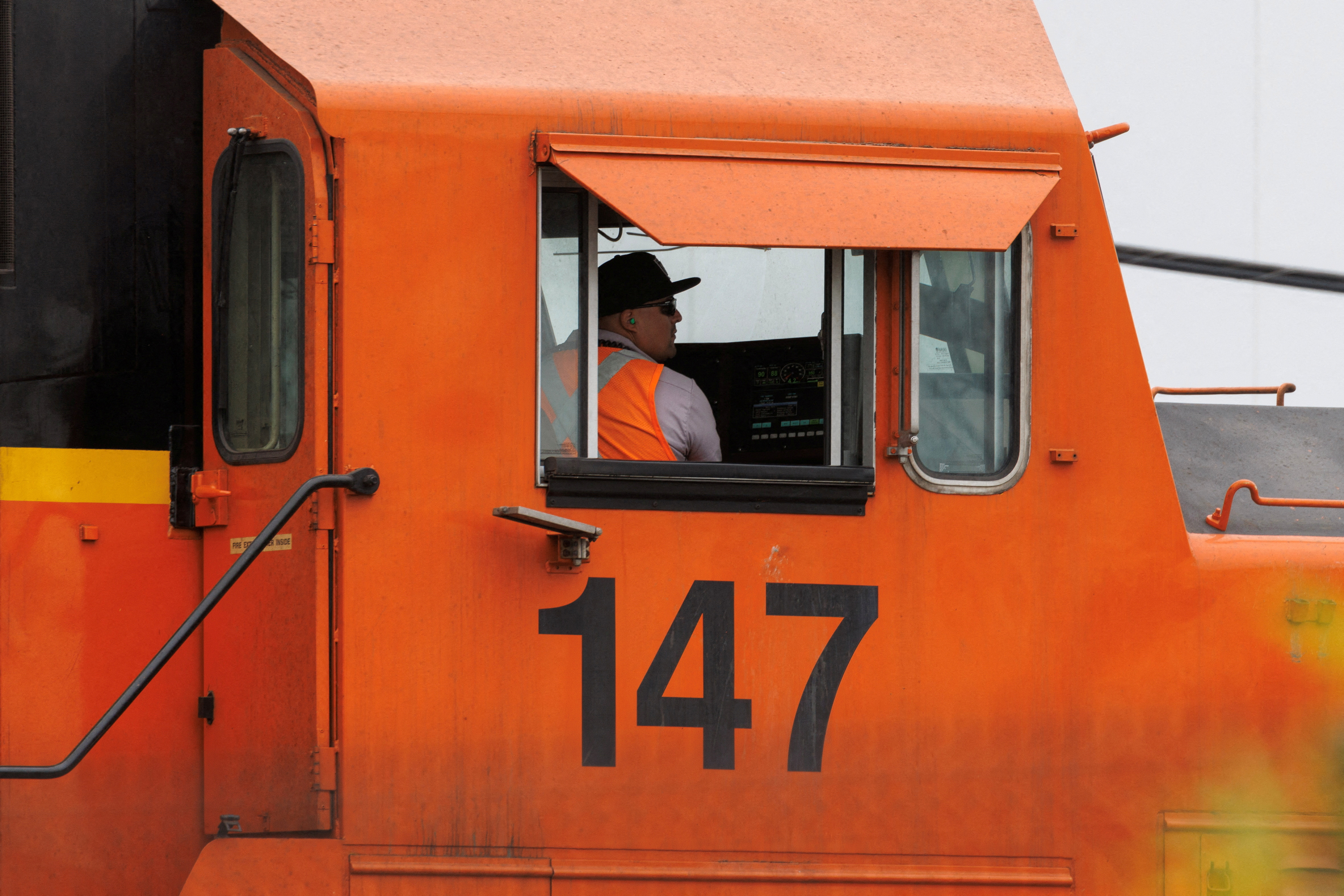 A railway worker drives a train engine while loading railcars in San Diego, California, Nov. 30, 2022.