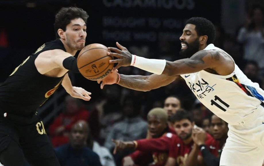 Cleveland Cavaliers forward Cedi Osman (16) and Brooklyn Nets guard Kyrie Irving (11) go for a loose ball during the second half at Rocket Mortgage FieldHouse in Cleveland, Ohio, Dec. 26, 2022.