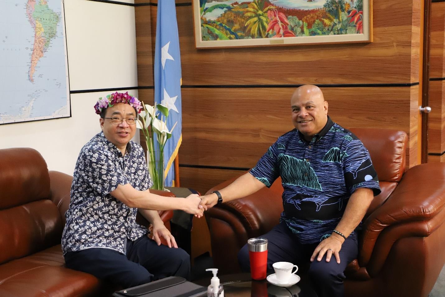 David W. Panuelo, president of the FSM, shakes hands with Huang Zheng, ambassador of the People’s Republic of China.
