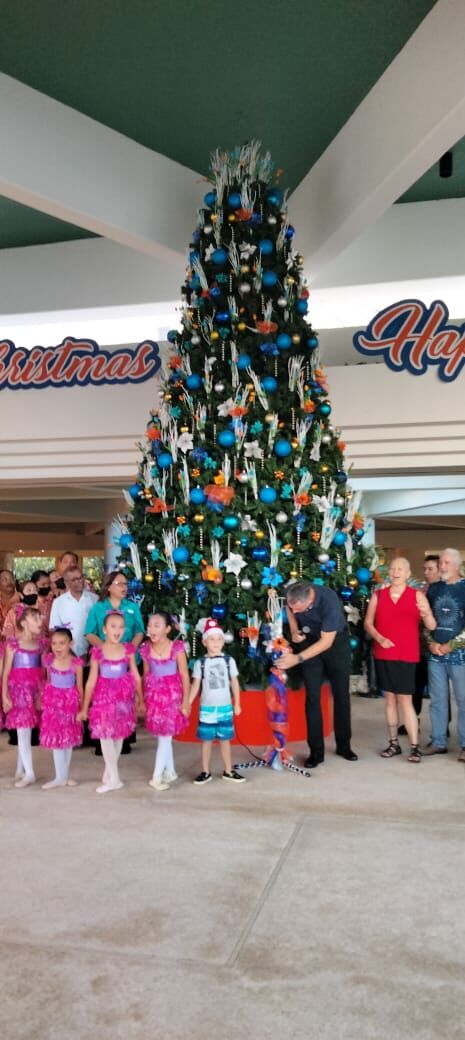 Glushko's Dance Academy students, Hyatt employees and other community members pose for a photo near Hyatt Regency Saipan’s Christmas tree, Thursday.