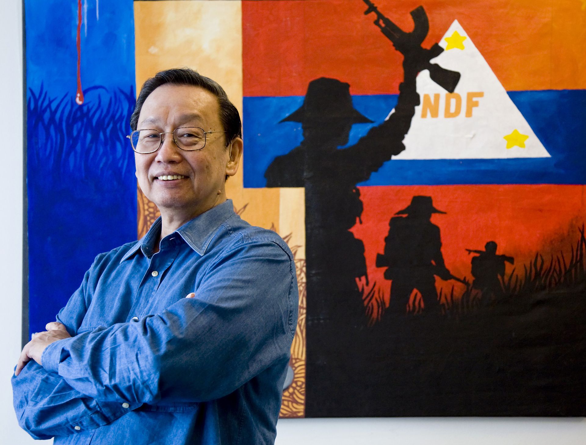 Communist Party of the Philippines founder Jose Maria Sison poses in front of a poster of the National Democratic Front, the political arm of the Maoist rebels, in Utrecht, the Netherlands on July 16, 2007.