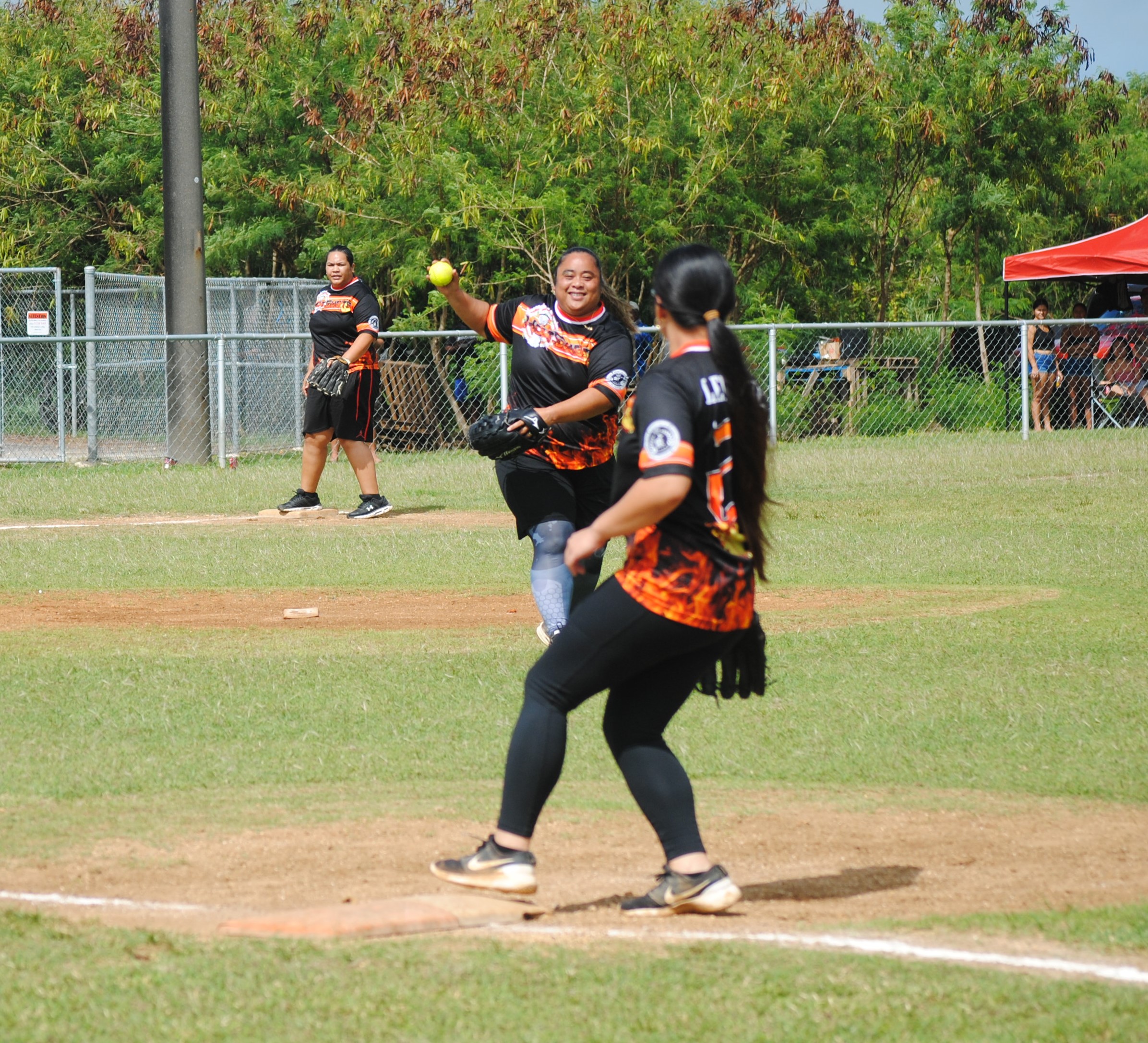 Hotshots pitcher Janice Celis smiles as she throws to first baseman Sablan for the out during game 1 of the women's division championship of the 2022 Budweiser Belau Amateur Softball League on Saturday at Dandan baseball field.