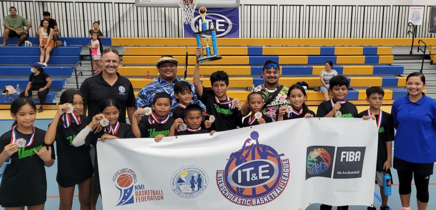 Koblerville Elementary School players pose with Public School System Athletic Program Director Nick Gross and NMI Basketball Federation Board Member Marlene Lumabi after winning the co-ed elementary school division championship of the IT&E Interscholastic Basketball League  on Saturday at the MHS gym.