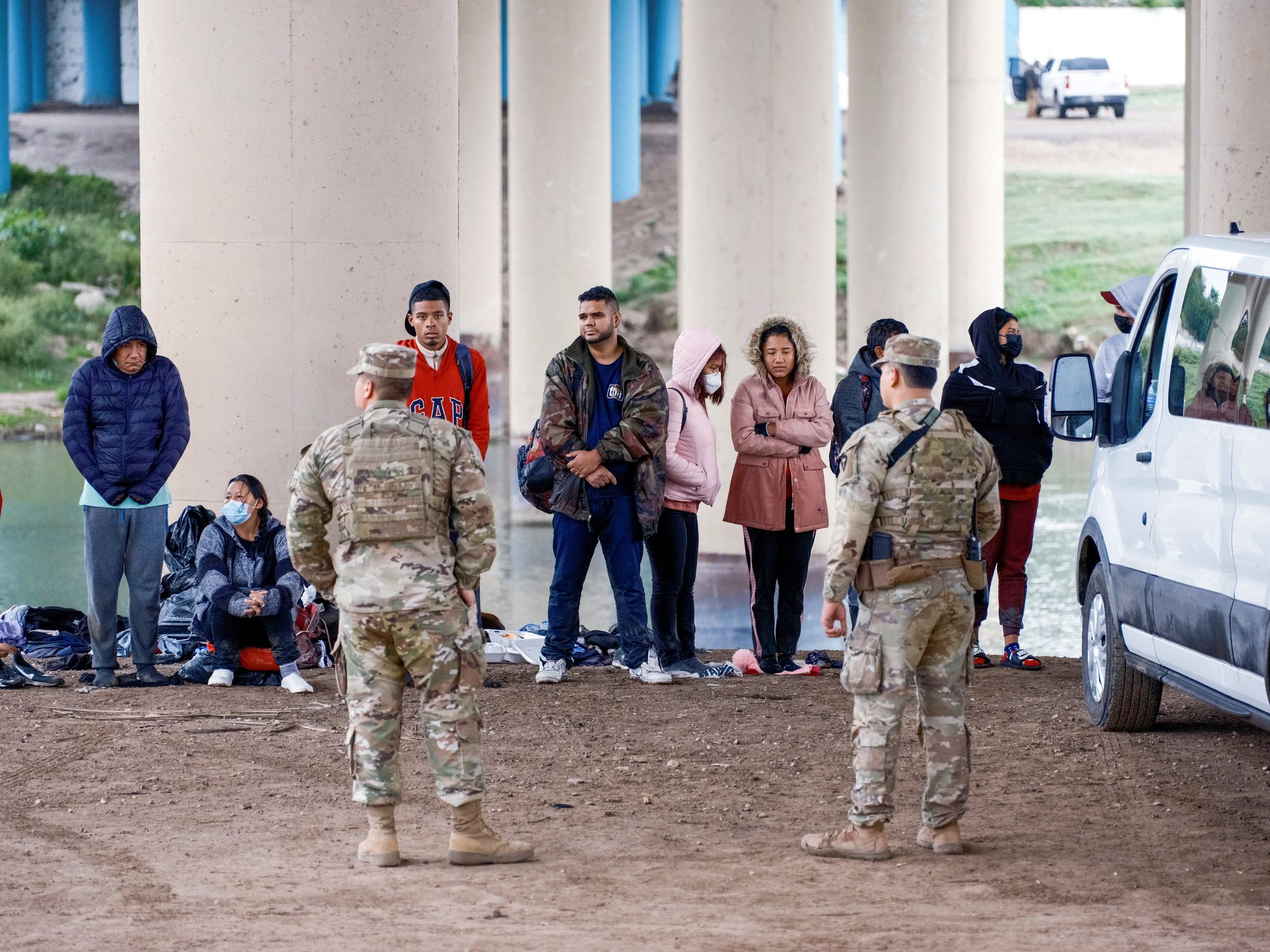 A group of migrants is processed by Texas National Guard after crossing the Rio Grande as U.S. border cities are bracing for an influx of asylum seekers when Covid-19-era Title 42 migration restrictions are set to end, in Eagle Pass, Texas, Dec. 19, 2022.