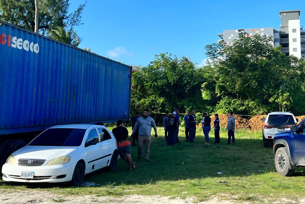 Police investigators are seen in a vacant lot near the Triple J Store in Chalan Kanoa where the body of a missing man was found Friday.