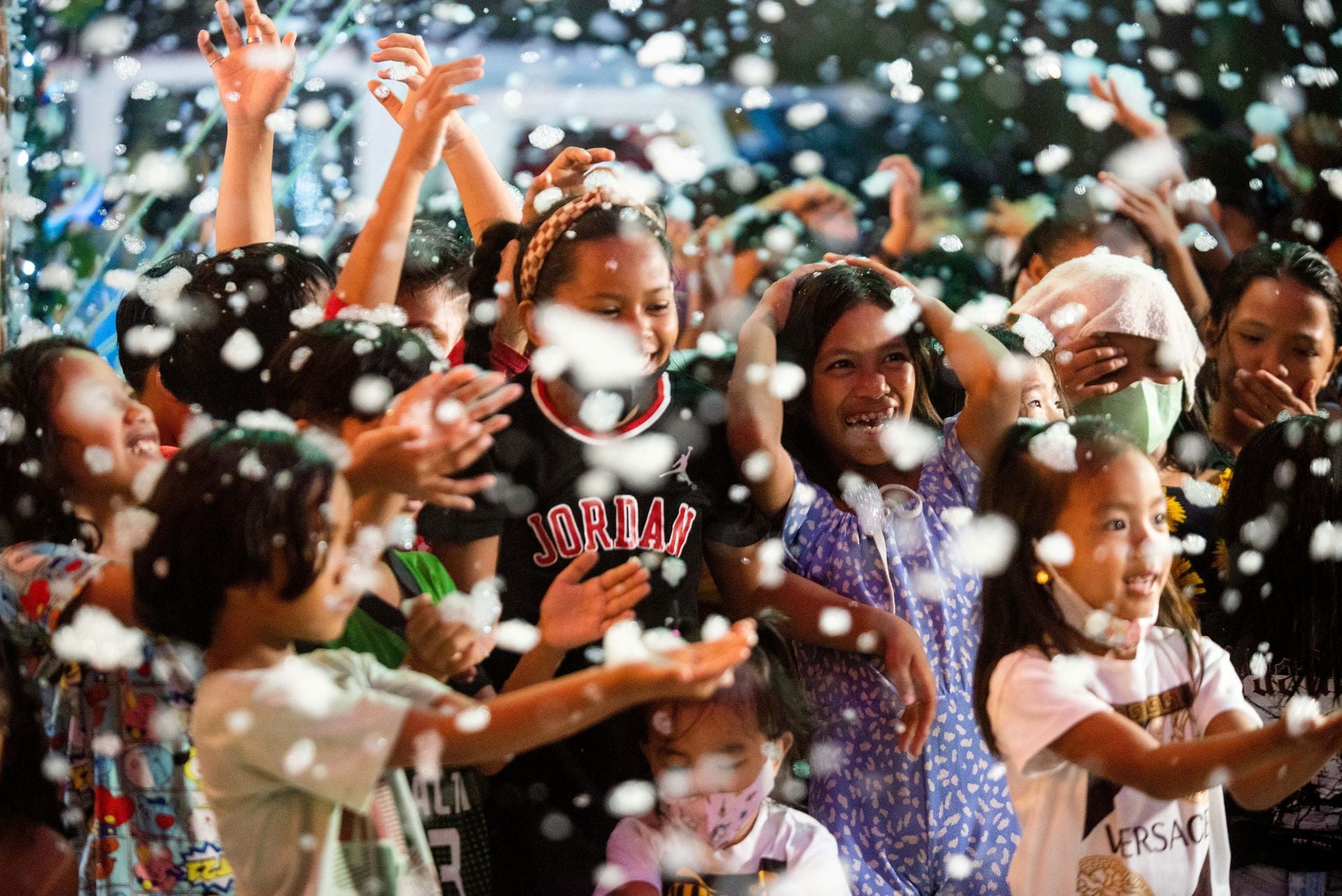 Children enjoy fake snow outside a Christmas-themed house, in Manila, the Philippines, Dec. 11, 2022.