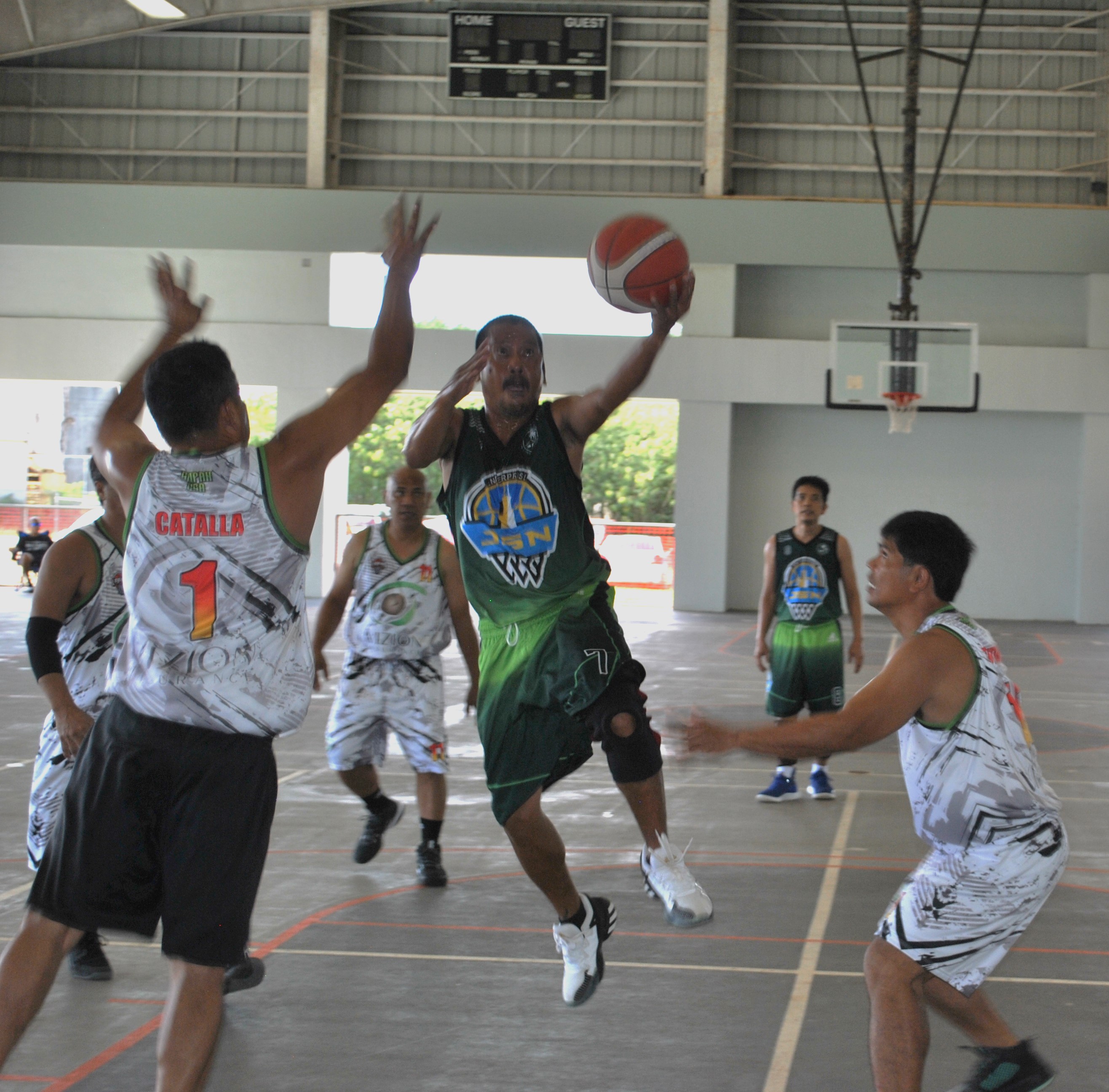JSN's Bernard Montano extends for the layup finish during a masters division game of the Legends Sports Association Invitational Basketball League Sunday at the Koblerville gym.