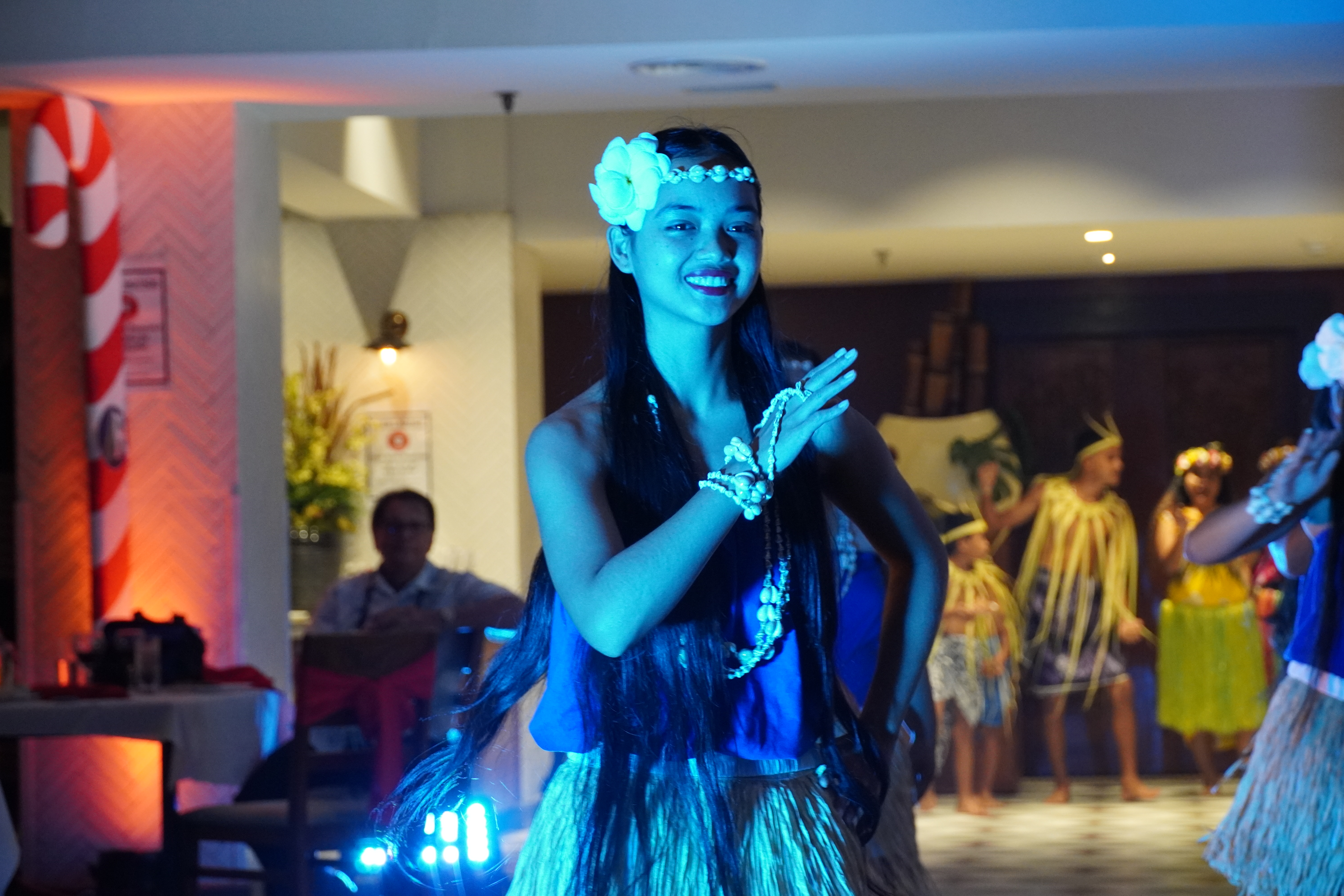 A young Chamorro cultural dancer smiles during a group performance.