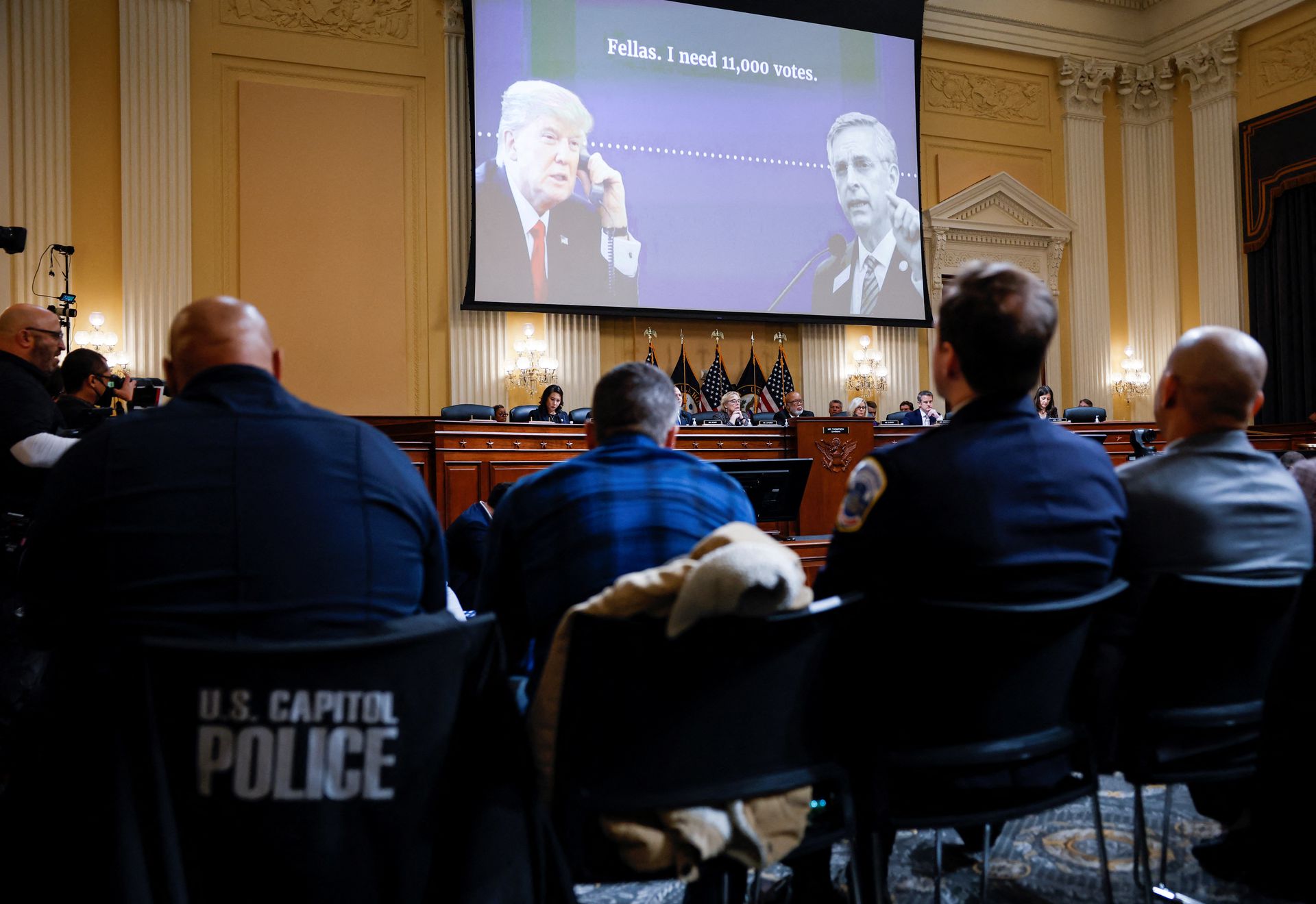 Members of the U.S. House Select Committee investigating the January 6 Attack on the U.S. Capitol sit beneath an image showing former President Donald Trump speaking on the telephone with Georgia Secretary of State Brad Raffensperger, as Capitol Hill police officer Harry Dunn, former Metropolitan Police Department officer Michael Fanone, MPD officer Daniel Hodges and U.S. Capitol Police Sgt. Aquilino Gonell attend the final meeting of the committee on Capitol Hill in Washington, D.C., Dec. 19, 2022.