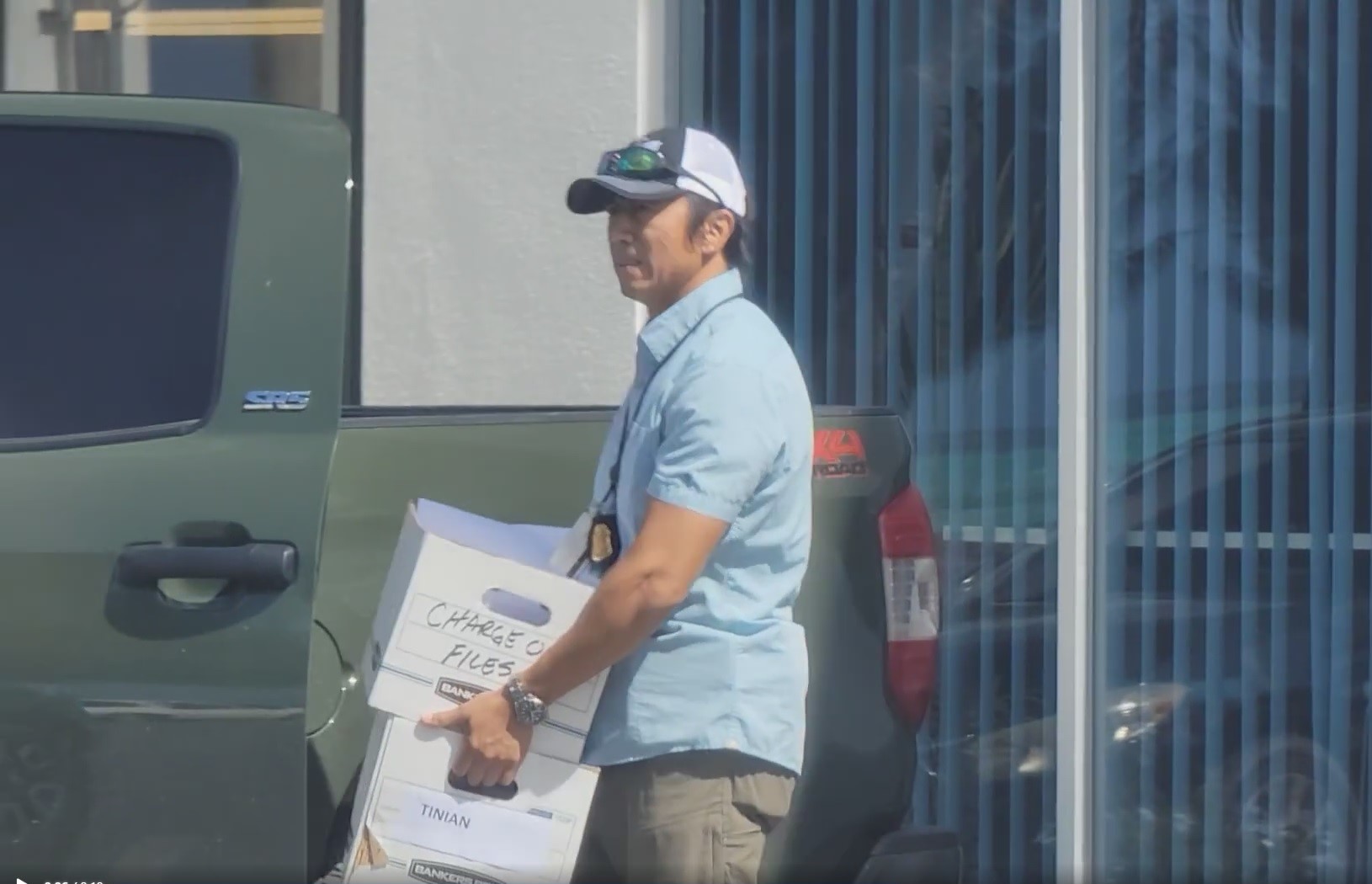 An FBI agent carries boxes of documents from Bank of Saipan on Monday.