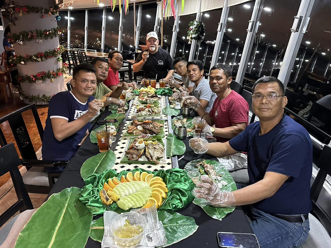 360 Revolving Restaurant owner Andy Colburn poses for a photo with “boodle fight” guests, from left, Arvin Jed Bautista, Sherwin Isip, Rowell Bautista, Andy, Ranniel Reyes, Albert Manansala, Vicente Berongan and Rolando Reyes.