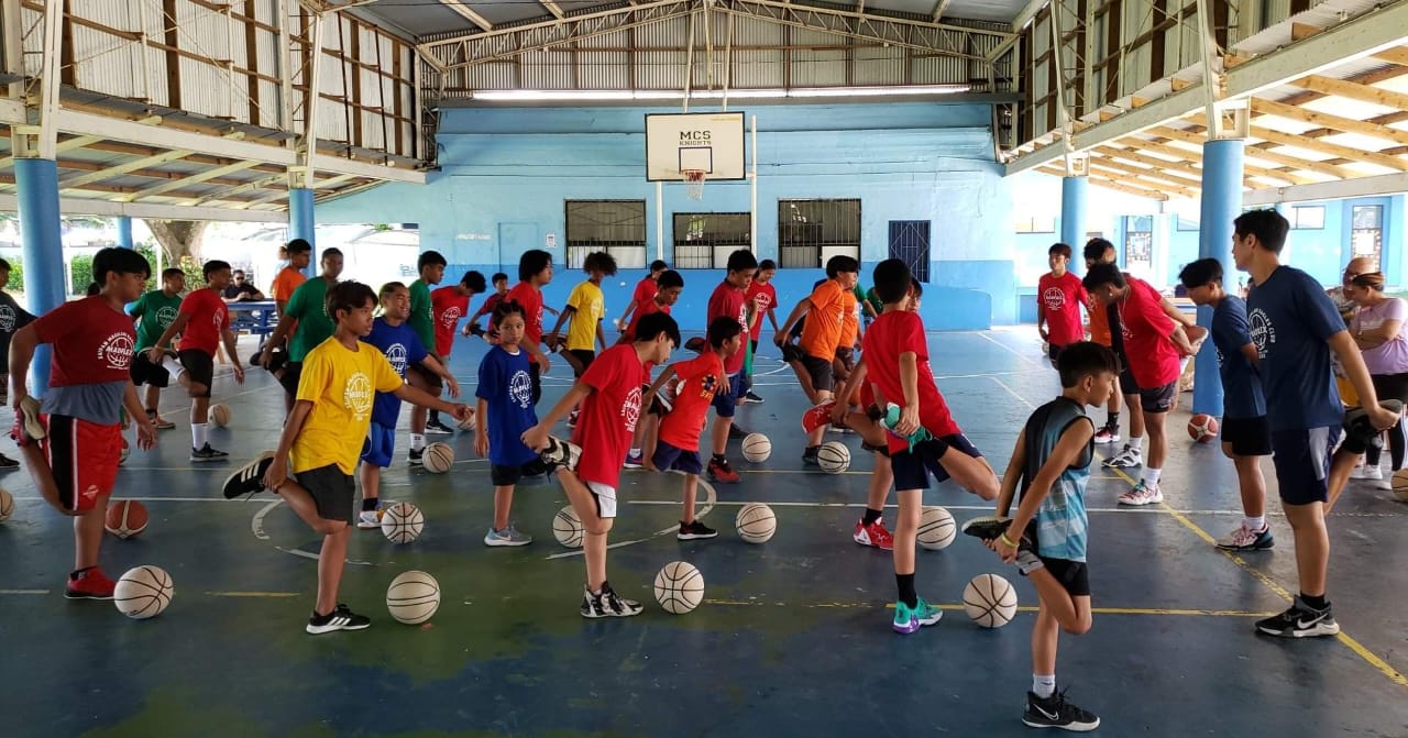 Basketball clinic participants perform stretches.