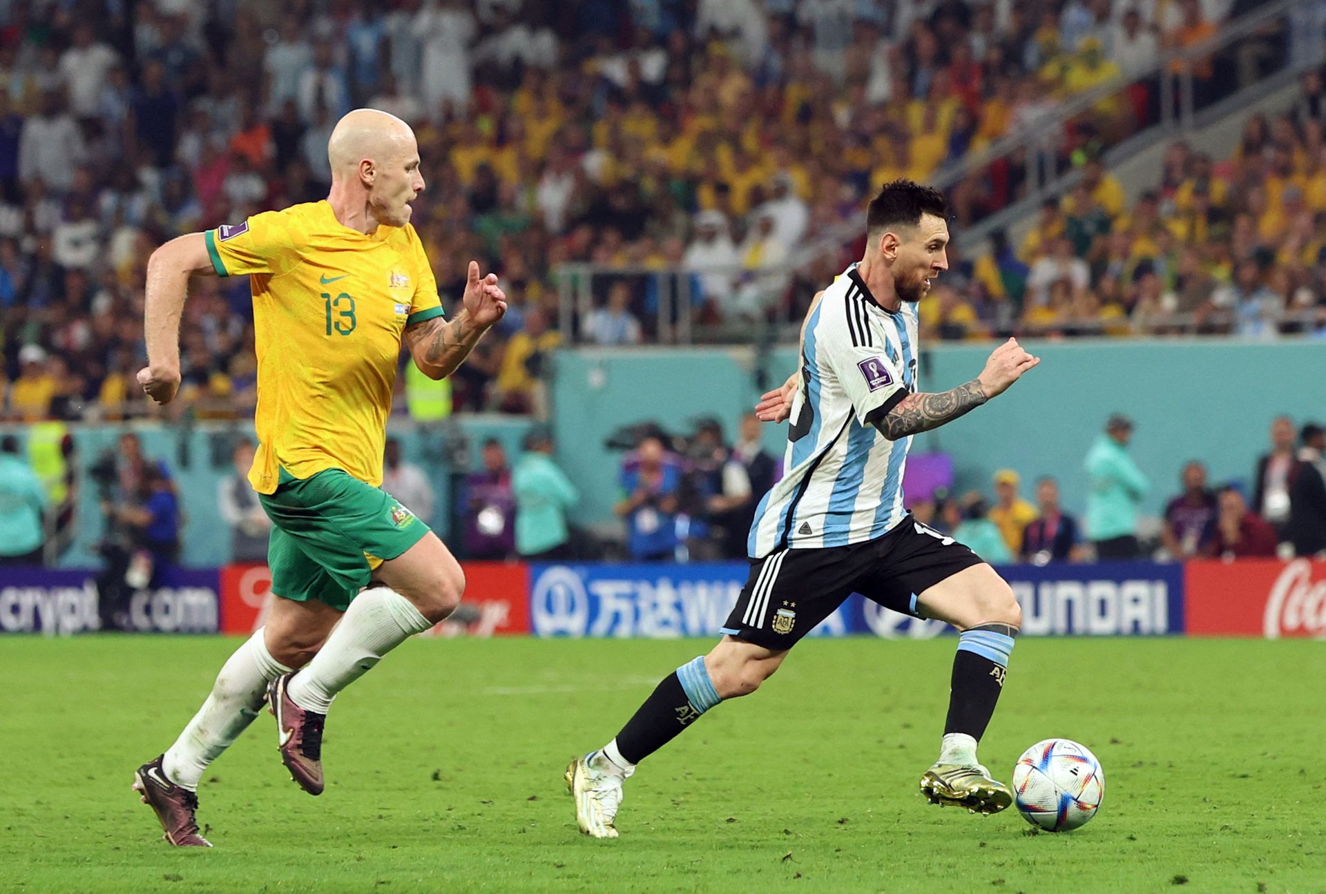 Australia's Aaron Mooy in in World Cup action with Argentina's Lionel Messi at Ahmad bin Ali Stadium in Al Rayyan, Qatar, Dec. 3, 2022.