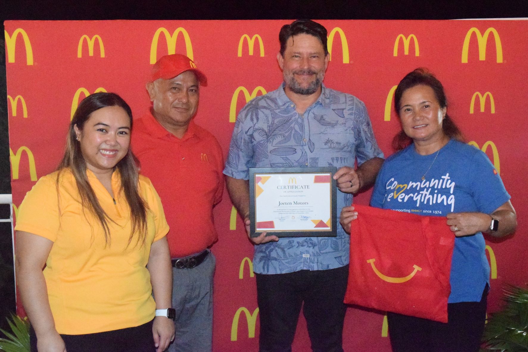 Joeten Motors general manager Matt Deets, center, displays a certificate of appreciation while posing for a photo with McDonald's Restaurant Saipan owner/operator Marcia Ayuyu, right, executive assistant to the president Natalie Mable Ayuyu-Glenn, left, and committee chairman Ben Babauta.