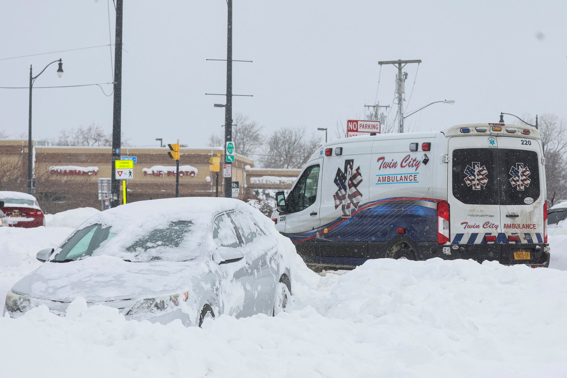 An ambulance passes an abandon car during a winter storm that hit the Buffalo region, in Amherst, New York, Dec. 26, 2022.