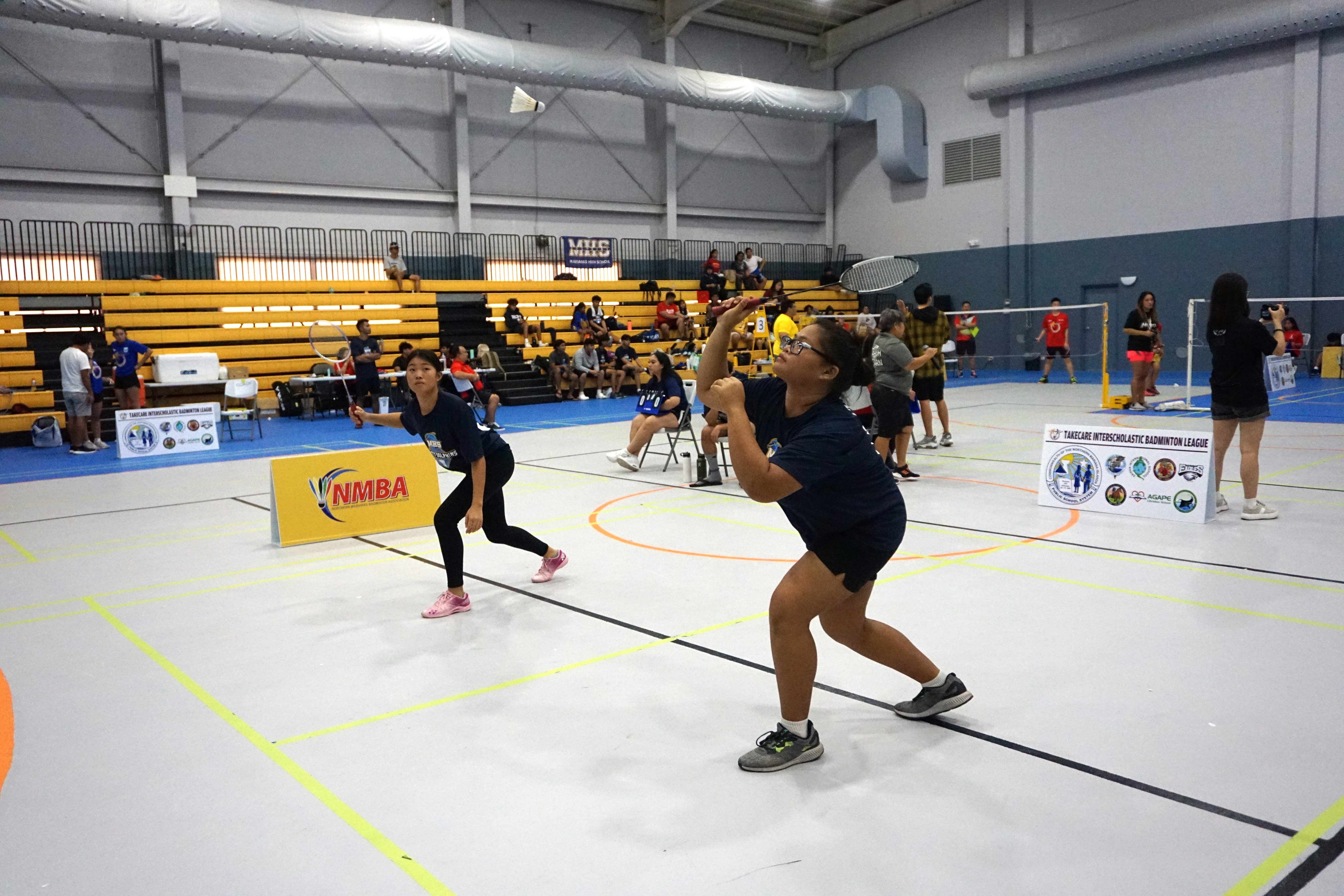 MHS 1's Shemariah Hicaro attempts the front-hand return alongside Terresa Ahn during a high school division game of the TakeCare-PSS Interscholastic Badminton League at the Ada gym.