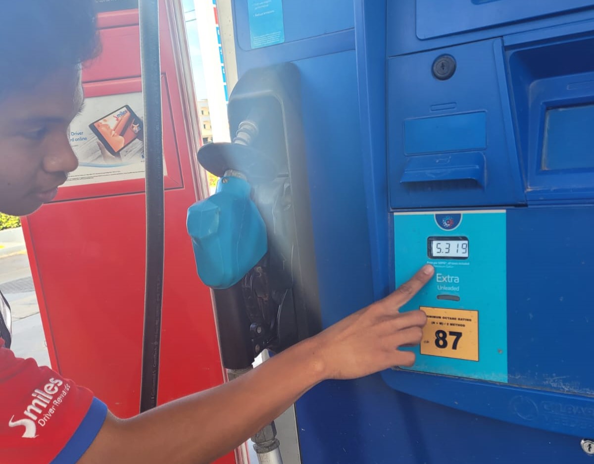 Mobil Garapan gas station attendant Troy Camacho points to the new regular gas price displayed at a gas pump on Wednesday.