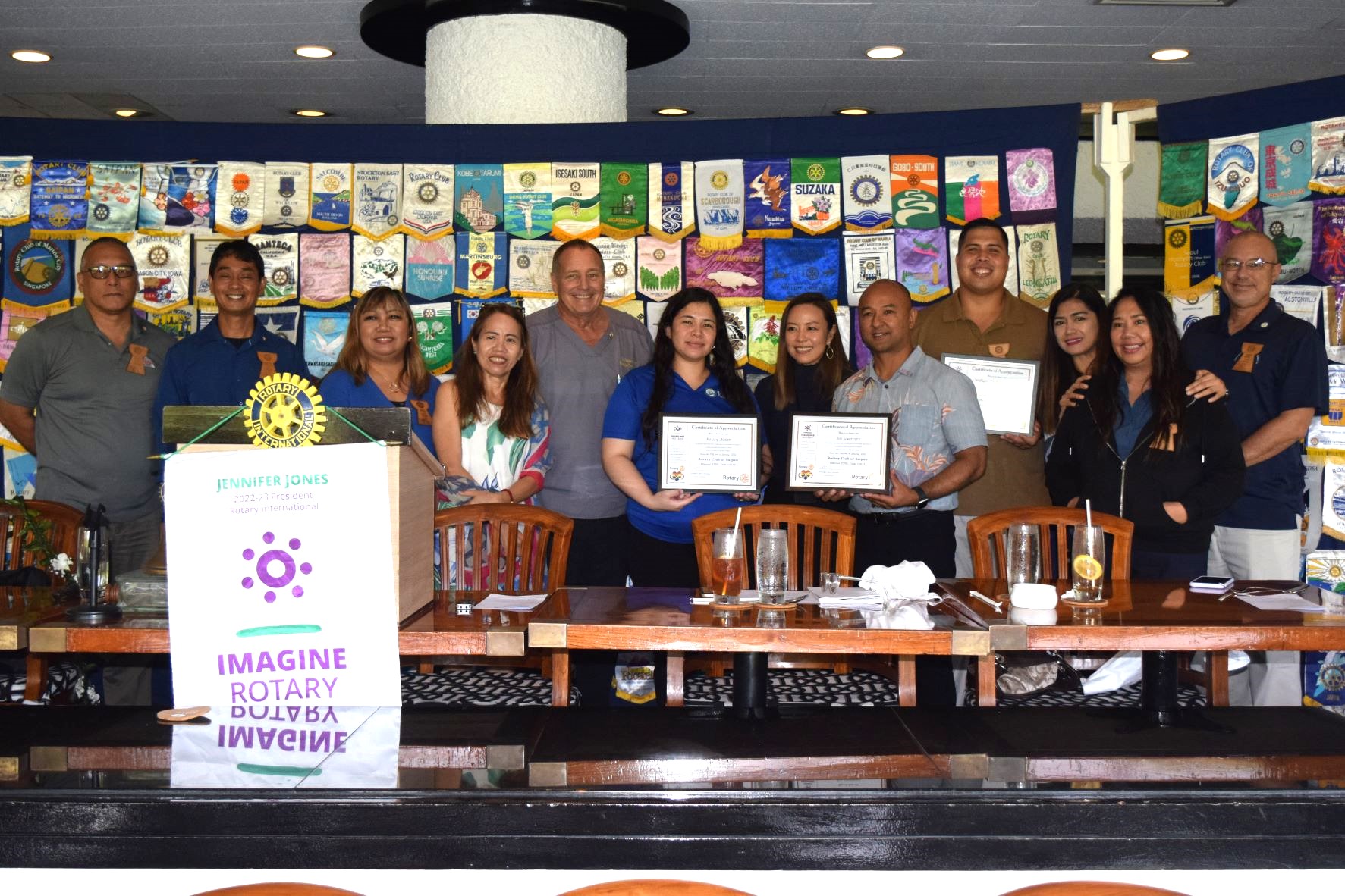 Commonwealth Recorder's Kelsey Aldan, center, TurnKey Solutions' Joe Guerrero, fifth right, and Billy Grow II, fourth right, pose for a photo with Rotary Club of Saipan President Wendell Posadas, second left, and other club officers after a presentation at the Hyatt Regency Saipan's Giovanni's Restaurant on Tuesday.