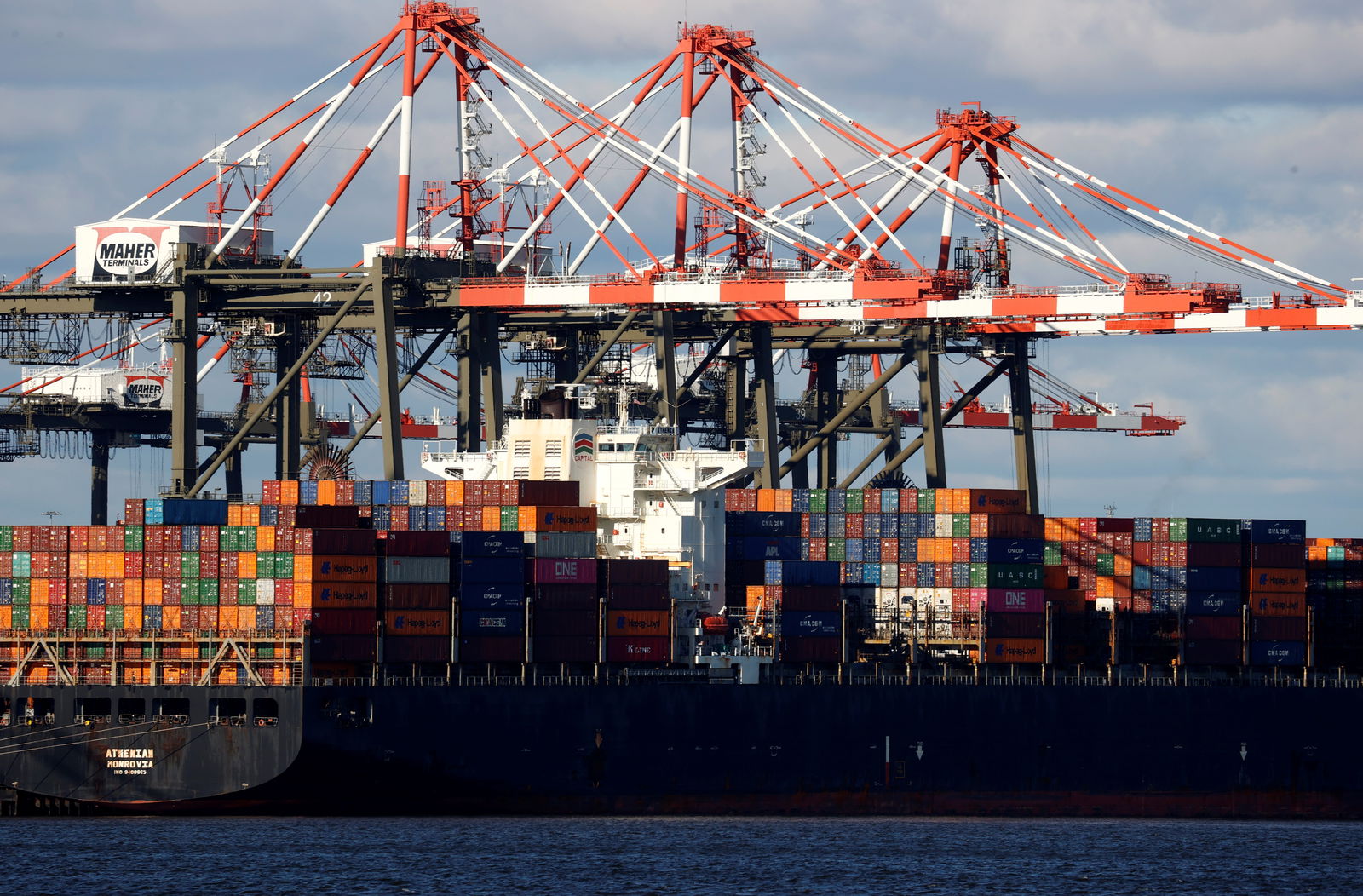 A ship stacked with shipping containers is unloaded on a pier at Port Newark, New Jersey, Nov. 19, 2021.