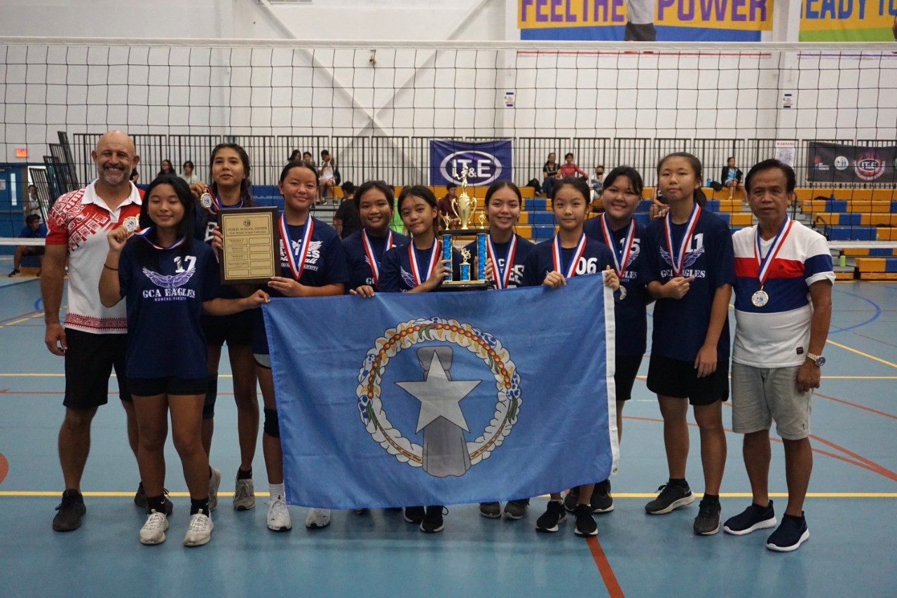 Grace Christian Academy’s volleyball team members pose with their medals, perpetual trophy and the CNMI flag after defeating Tanapag Middle School in the girls middle school division championship of the NMIVA-PSS Interscholastic Volleyball League on Saturday at the MHS gym.