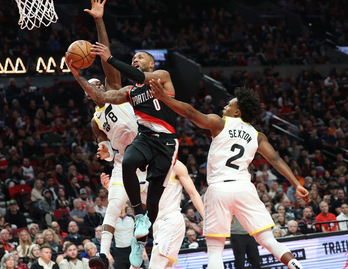 Portland Trail Blazers guard Damian Lillard (0) shoots over Utah Jazz forward Jarred Vanderbilt (8) and guard Collin Sexton (2) in the second half at Moda Center in Portland, Oregon, Jan. 25, 2023.