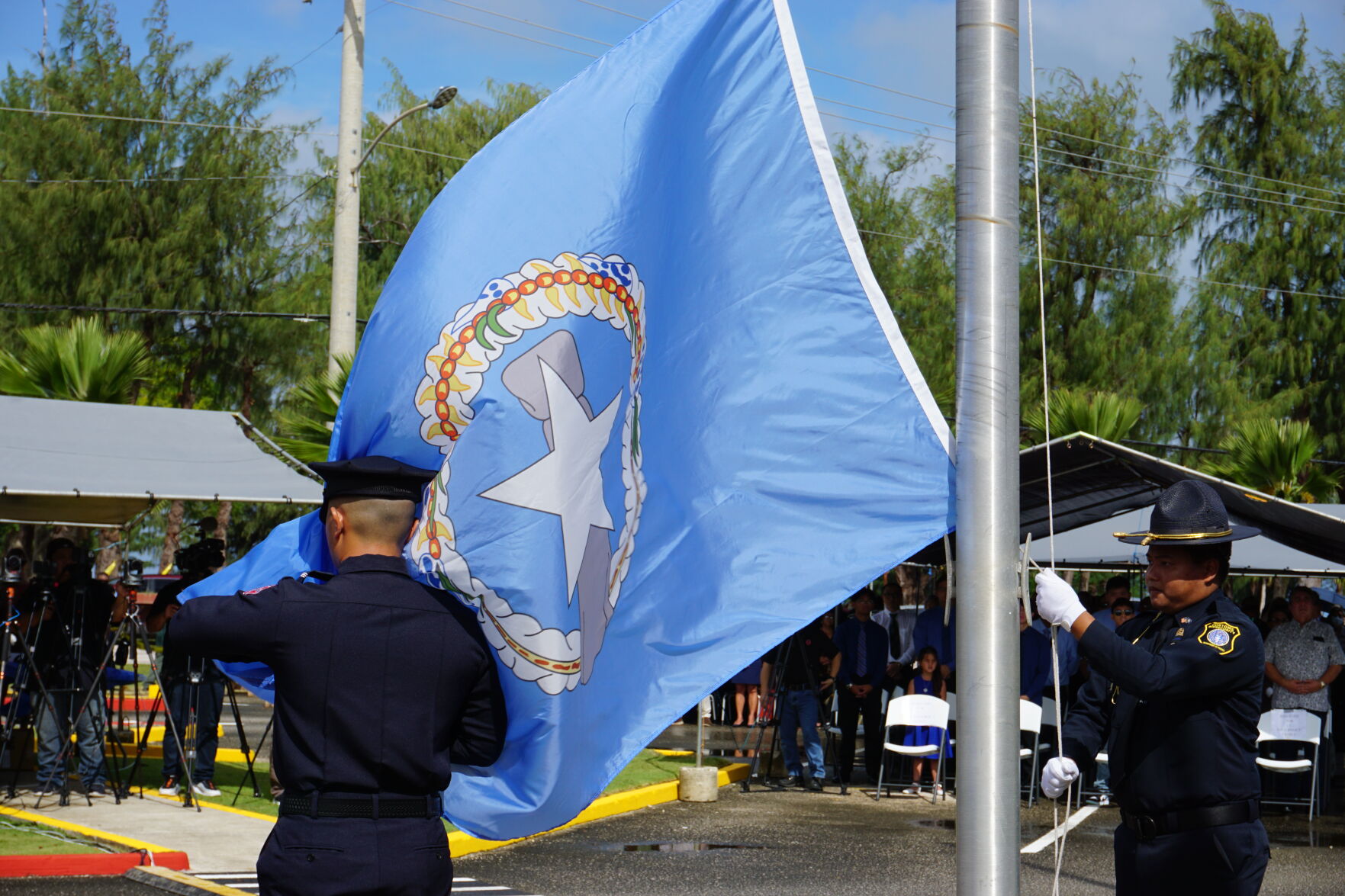 Two members of the CNMI Color Guard raise the CNMI flag.