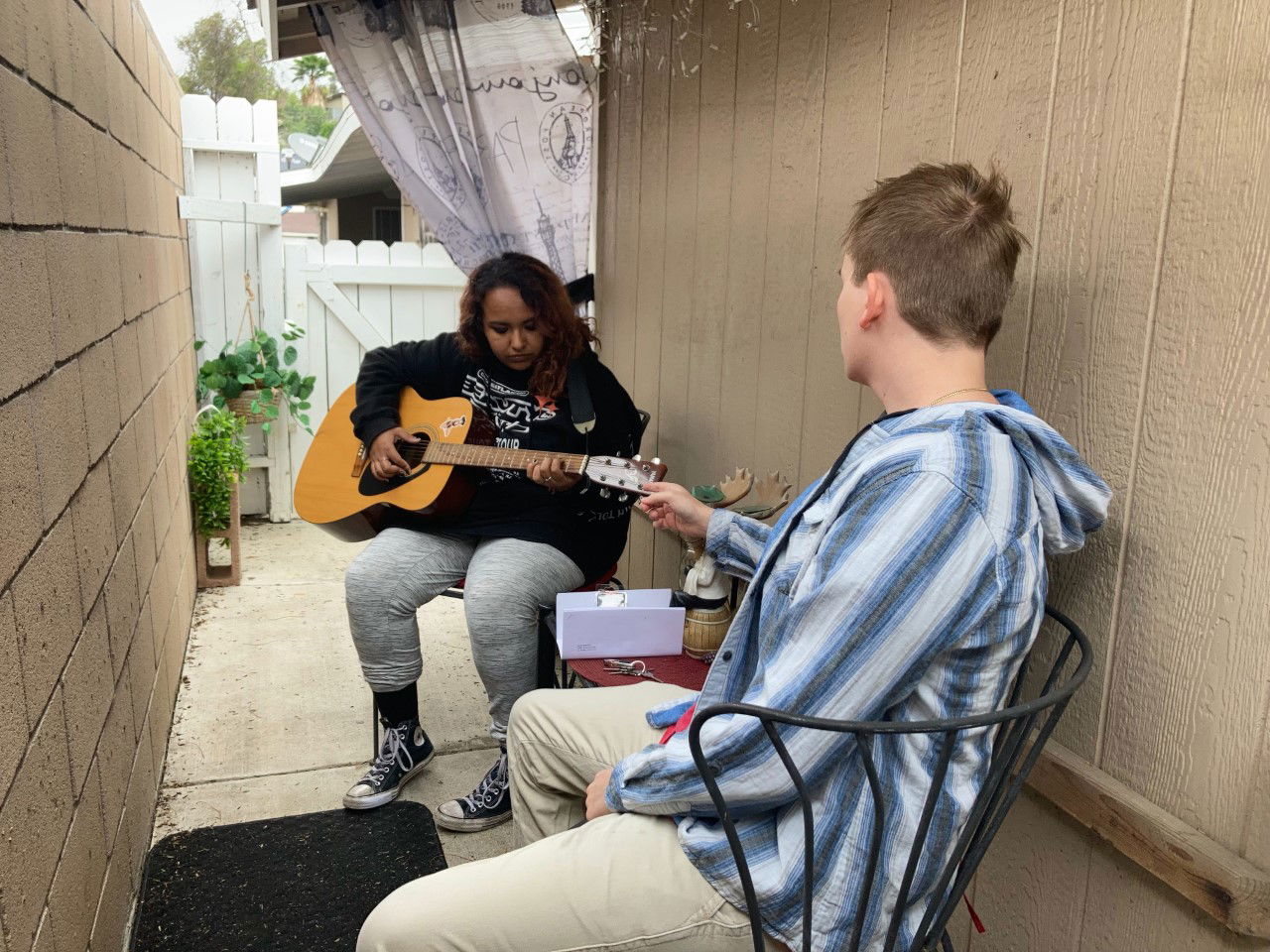 Carter Widmor, right, teaches a guitar student.