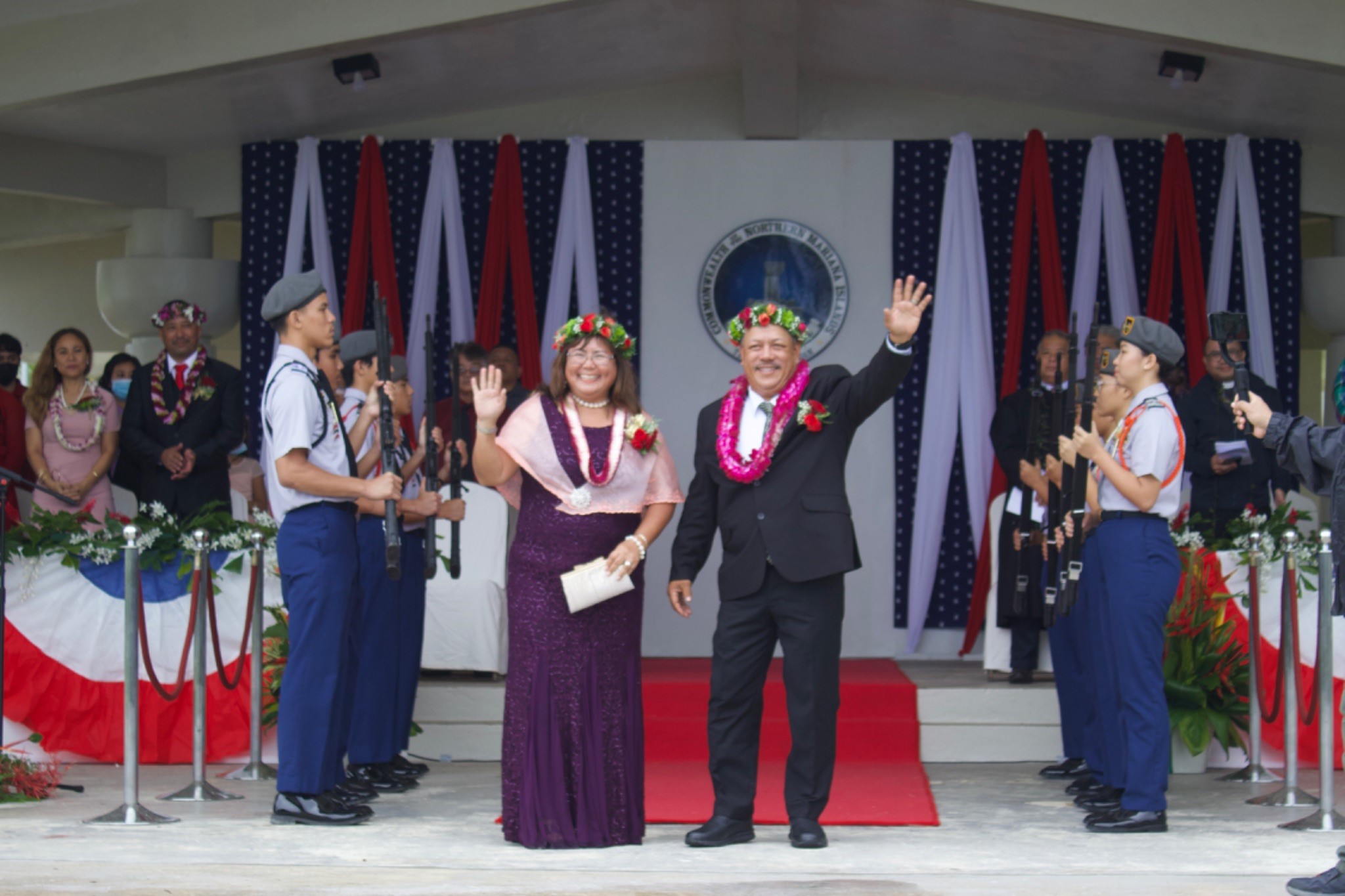 Tinian Mayor Edwin Palacios Aldan and Tinian's first lady Rosita Aldan wave at the crowd while the Stallion Battalion Honor Guard stood on both sides of the red carpet with rifles.