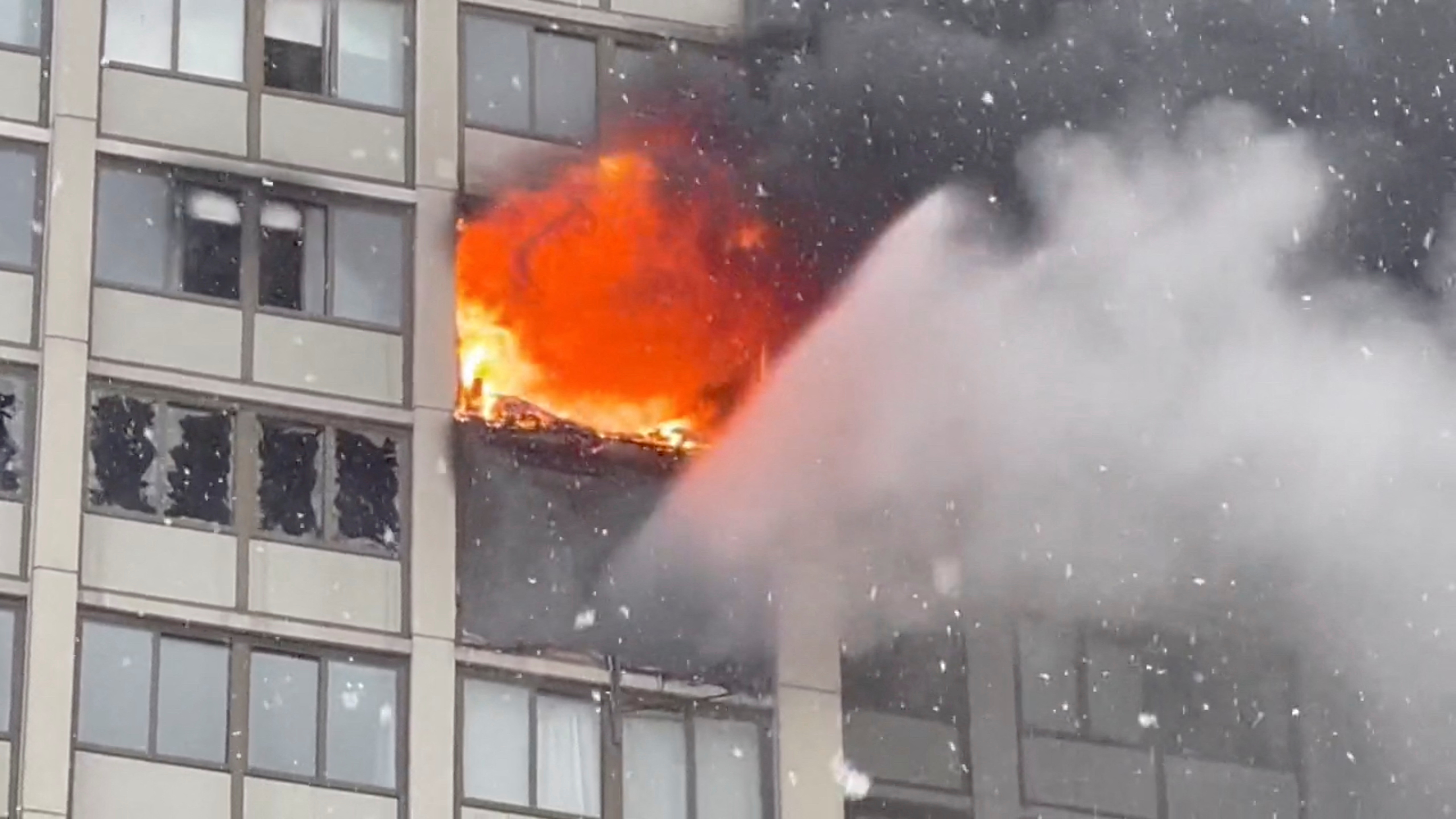 Fire rages in a high-rise apartment building on the South Side of Chicago, Illinois,  Jan. 25, 2023, in this still image obtained from a social media video.