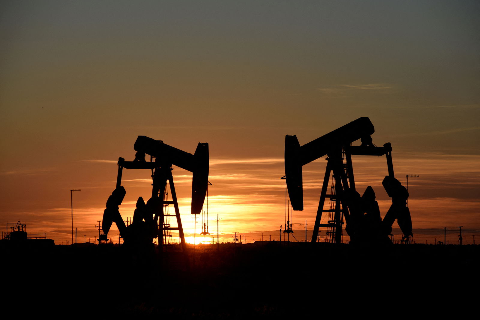 Pump jacks operate at sunset in an oil field in Midland, Texas, Aug. 22, 2018.