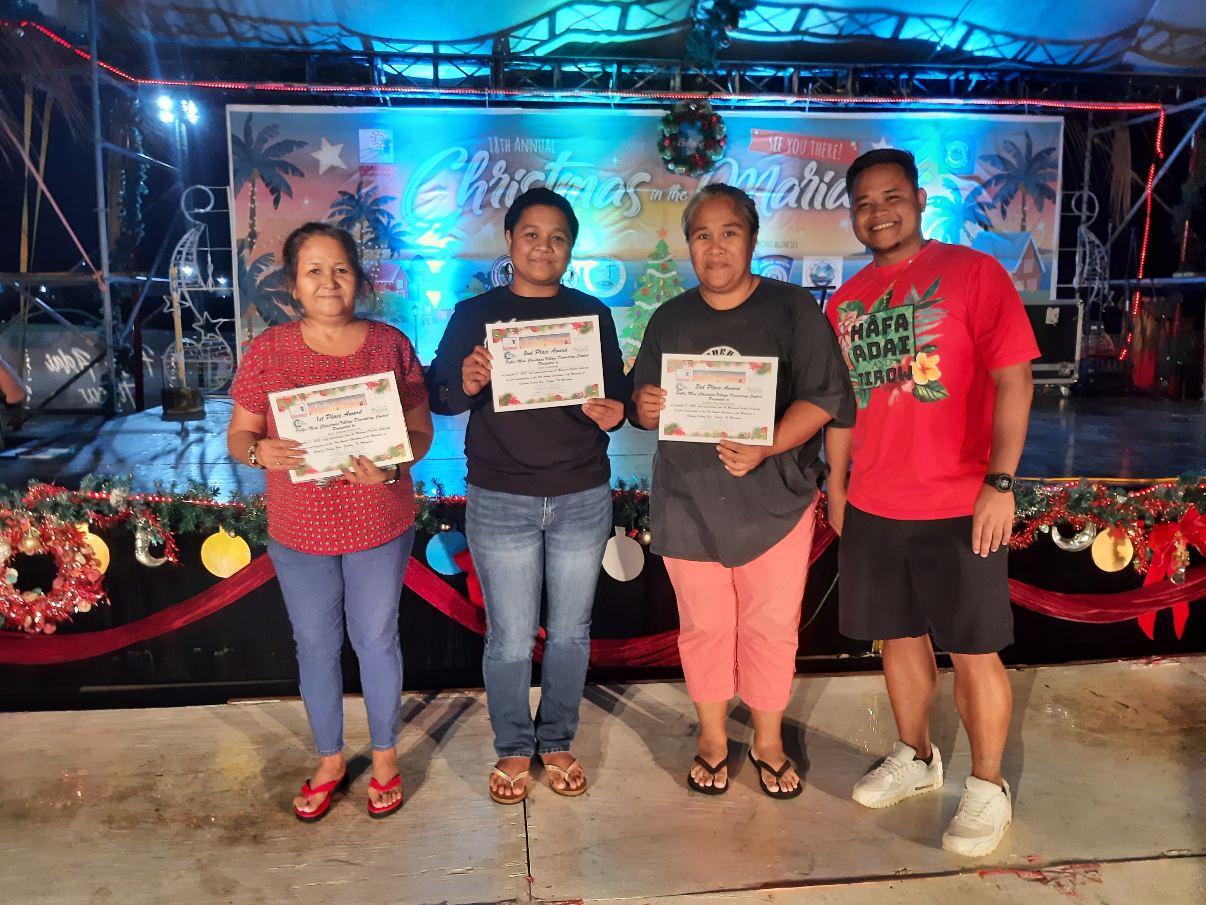 Winners of the Mini Christmas Village Contest are awarded on Jan. 7, 2023 during the 18th Annual Christmas in the Marianas at Garapan Fishing Base, Saipan.  From left, 1st place winner Lucy Deleon Guerrero, 2nd place Gina Nabetinan, 3rd place  Sharma Iginoef Laniyo, and Marianas Visitors Authority Community Projects Specialist Jack Aranda.