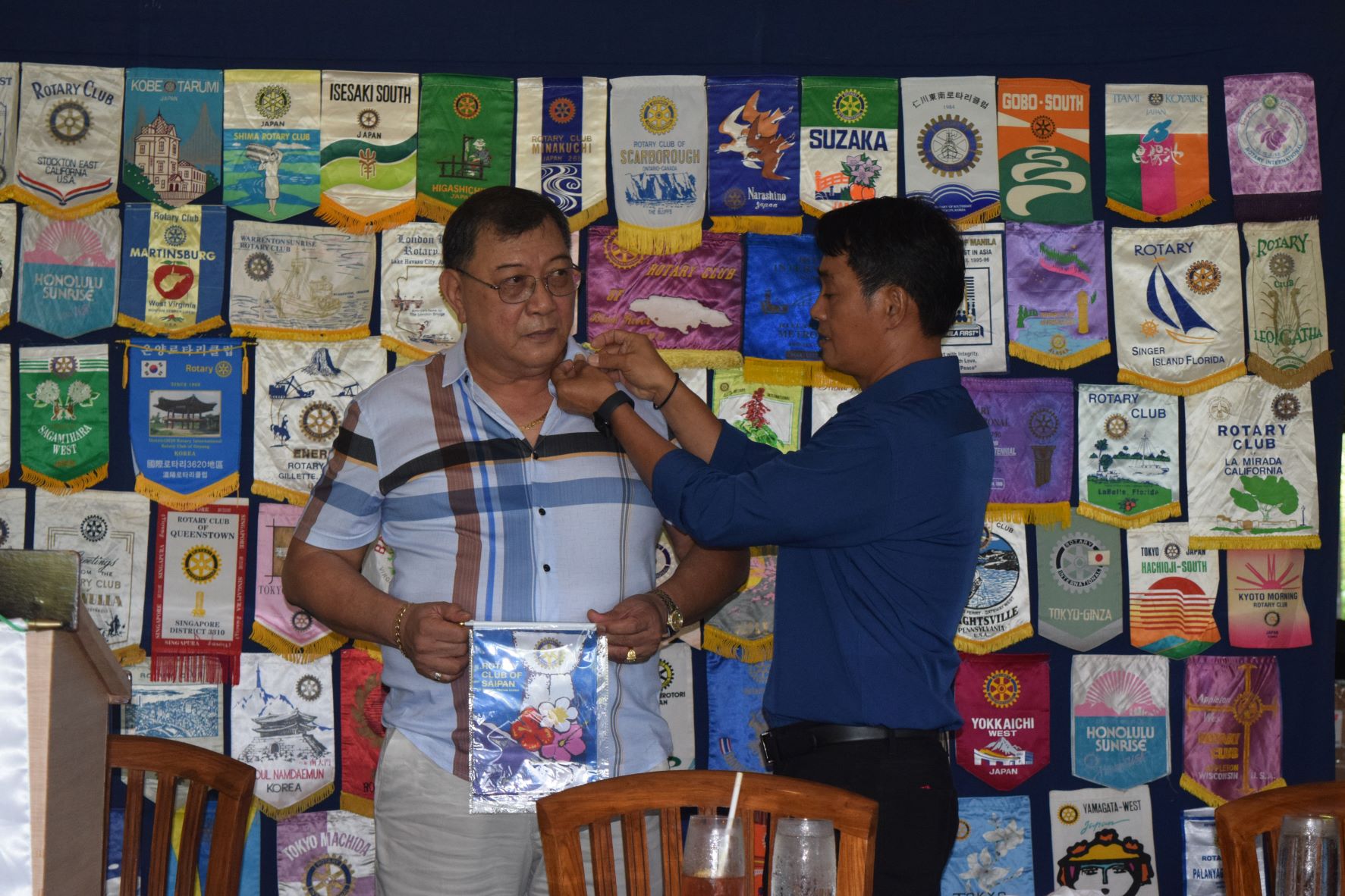 Rotary Club of Saipan President Wendell Posadas pins Wilfredo Ching to welcome him as a new club member at the Hyatt Regency Saipan's Giovanni's Restaurant on Tuesday last week.