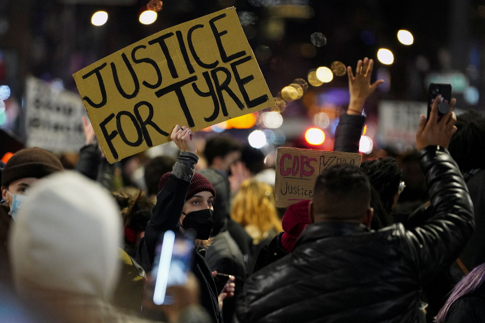People hold signs during a protest following the release of videos showing Memphis police officers beating Tyre Nichols, who died while hospitalized three days later, in New York, Jan. 28, 2023.