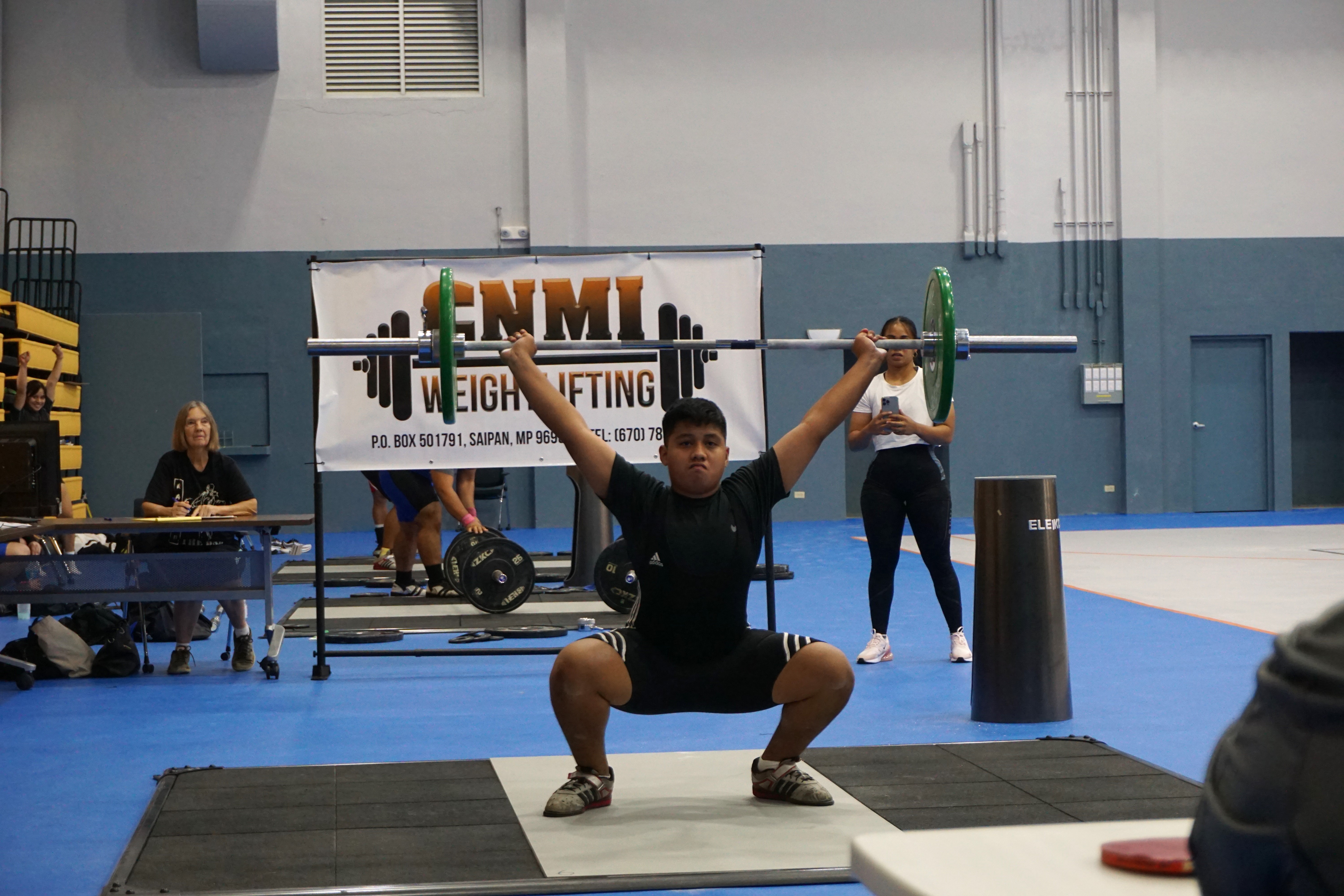 Youth lifter Kiien Manuel powers through a successful snatch lift during the CNMI Weightlifting qualifier tournament on Saturday at the  Ada gym.