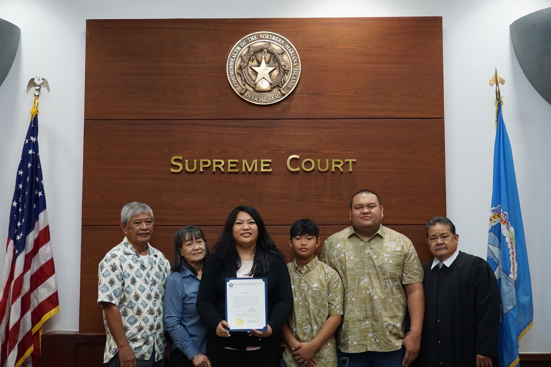 Rota Mayor Aubry M. Hocog holds her signed oath of office and poses for a photo with her father, mother, son, partner, and Chief Justice Alexander C. Castro who is also from Rota.