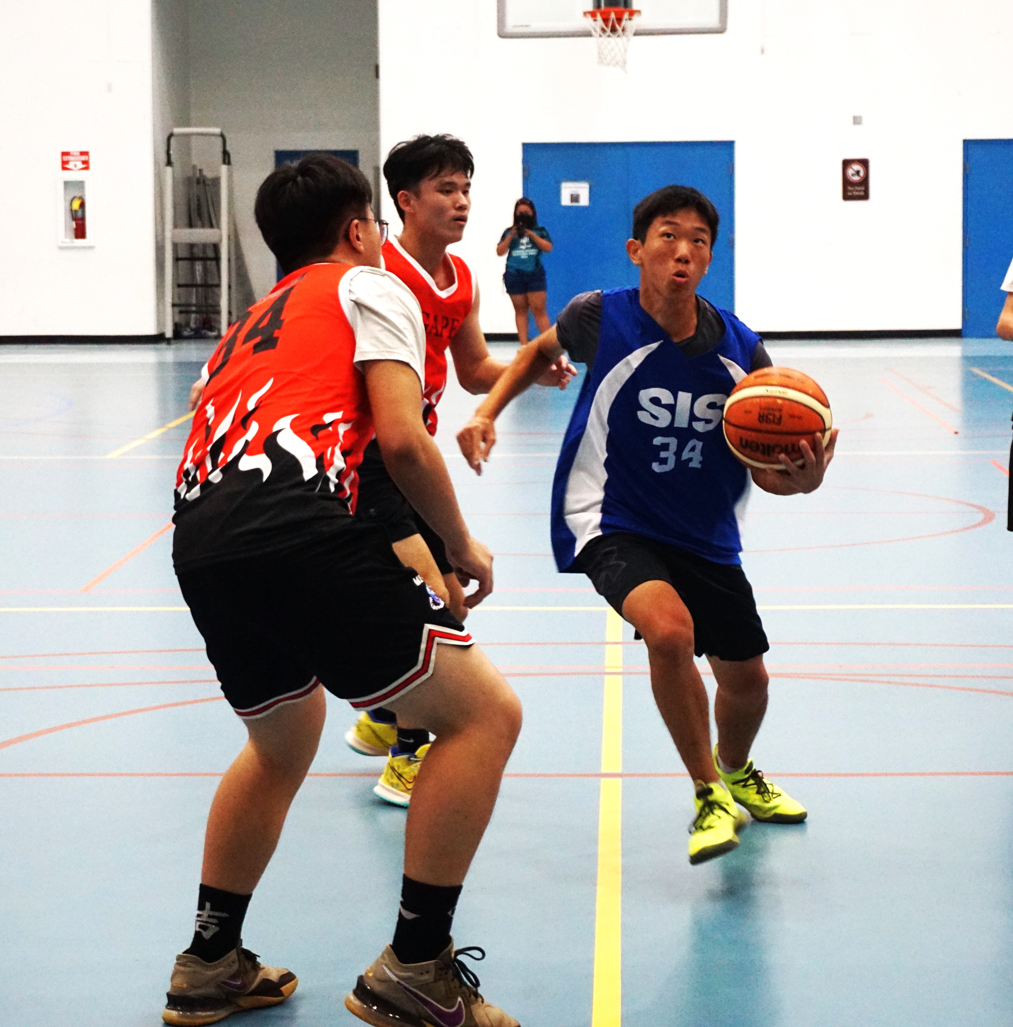 SIS' Nam Yunwoo protects the ball as he drives past ACS defenders during a boys high school division game of the IT&E Interscholastic Basketball League on Wednesday at the MHS gym.