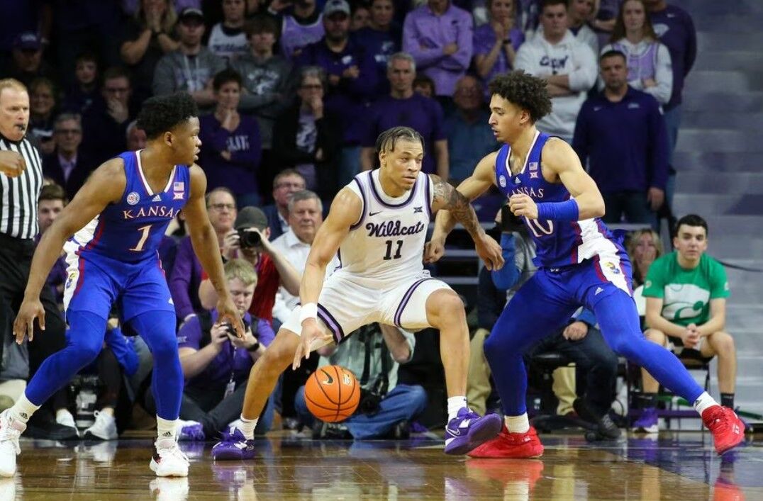 Kansas State Wildcats guard Keyontae Johnson (11) is guarded by Kansas Jayhawks forward Jalen Wilson (10) and Kansas Jayhawks guard Joseph Yesufu (1) during the second half at Bramlage Coliseum in Manhattan, Kansas, Jan. 17, 2023.