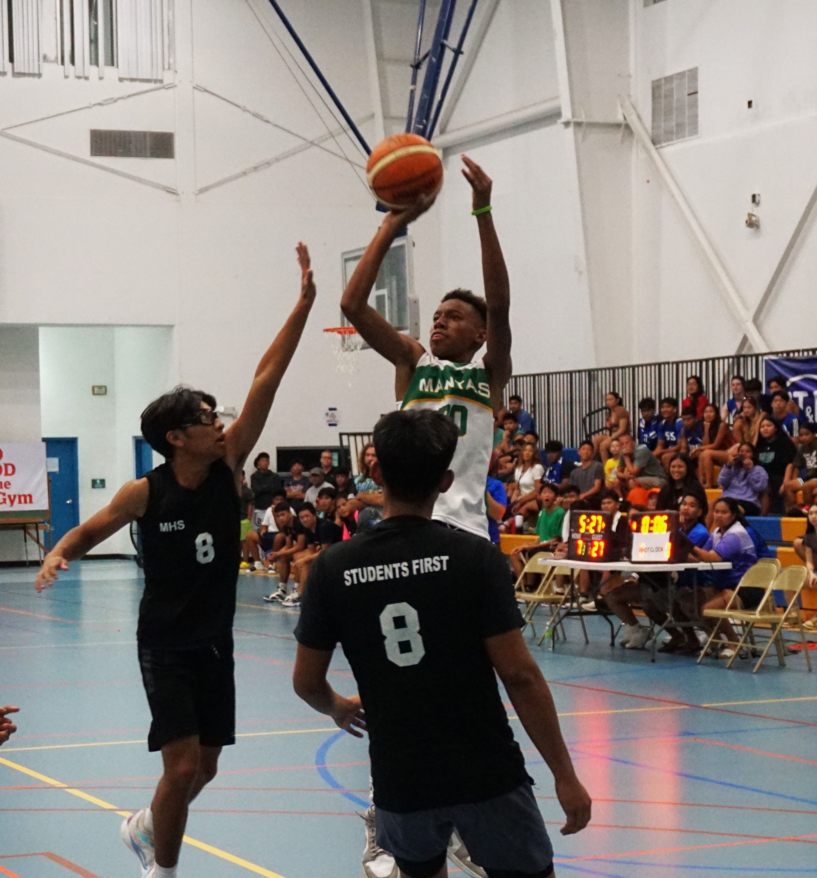 SSHS JV's Kian Helgen pulls up for the shot over two defenders during the opening game in the boys high school division of the IT&E Interscholastic Basketball League on Wednesday at the MHS gym.