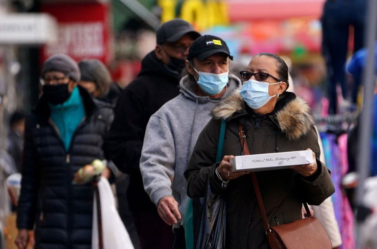 People walk outside wearing masks during the coronavirus disease pandemic in the Harlem area of the Manhattan borough of New York City, New York, Feb. 10, 2022.