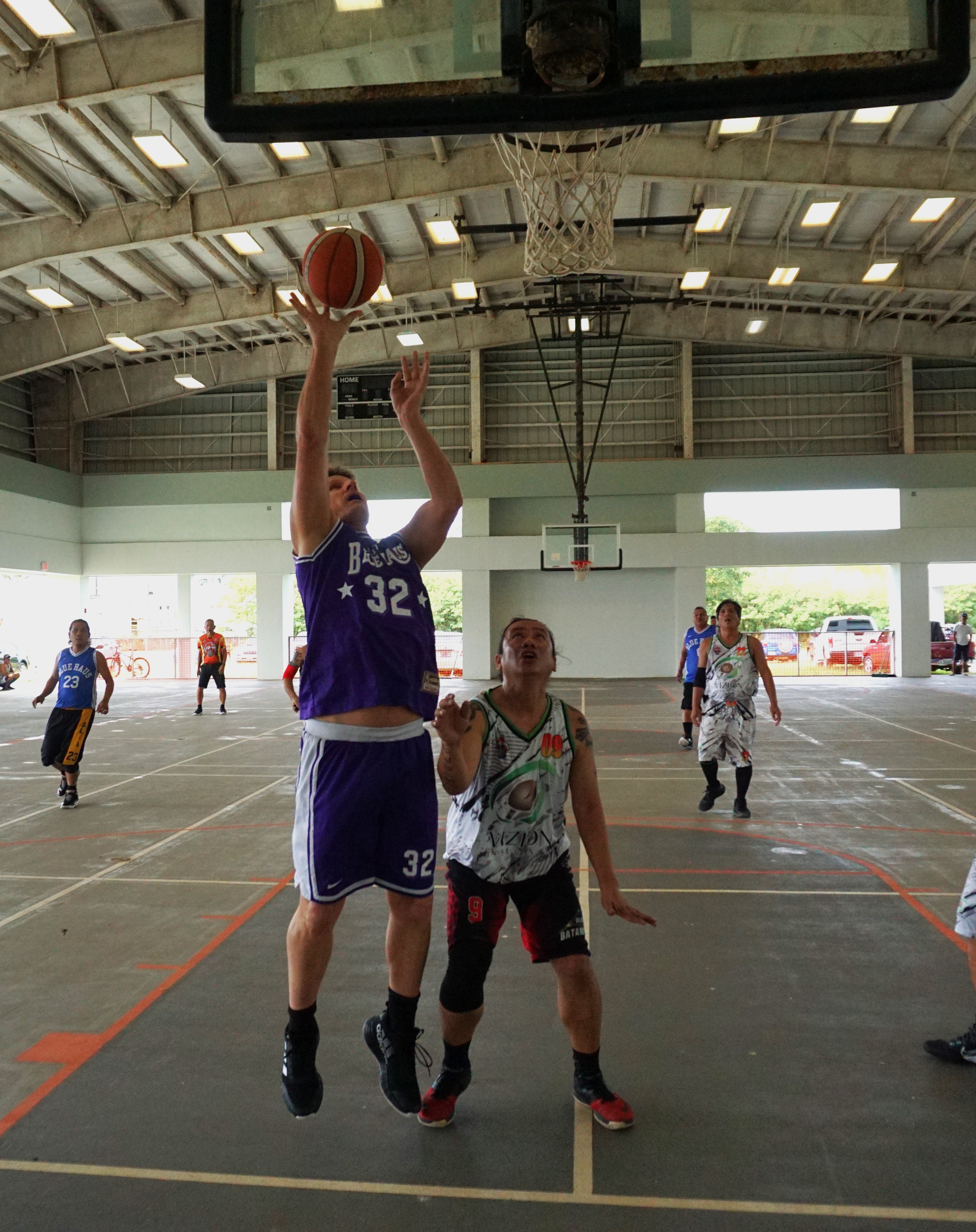 Blue Haus's Bruce Berline leaps for the finish from underneath the rim during a masters division semifinal game of the Legends Sports Association Invitational Basketball League on Sunday at the Koblerville gym.