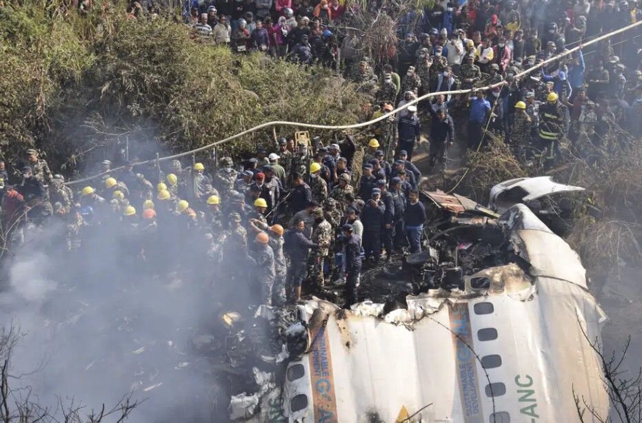 Nepalese rescue workers and civilians gather around the wreckage of a passenger plane that crashed in Pokhara, Nepal, Sunday, Jan. 15, 2023.
